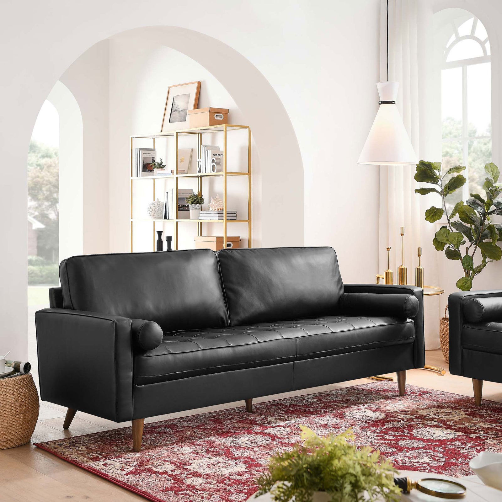 81 inch Valour black leather sofa anchors an airy living room with arched windows, red patterned rug, and modern decor. || EEI-4634-BLK || front_angle_room