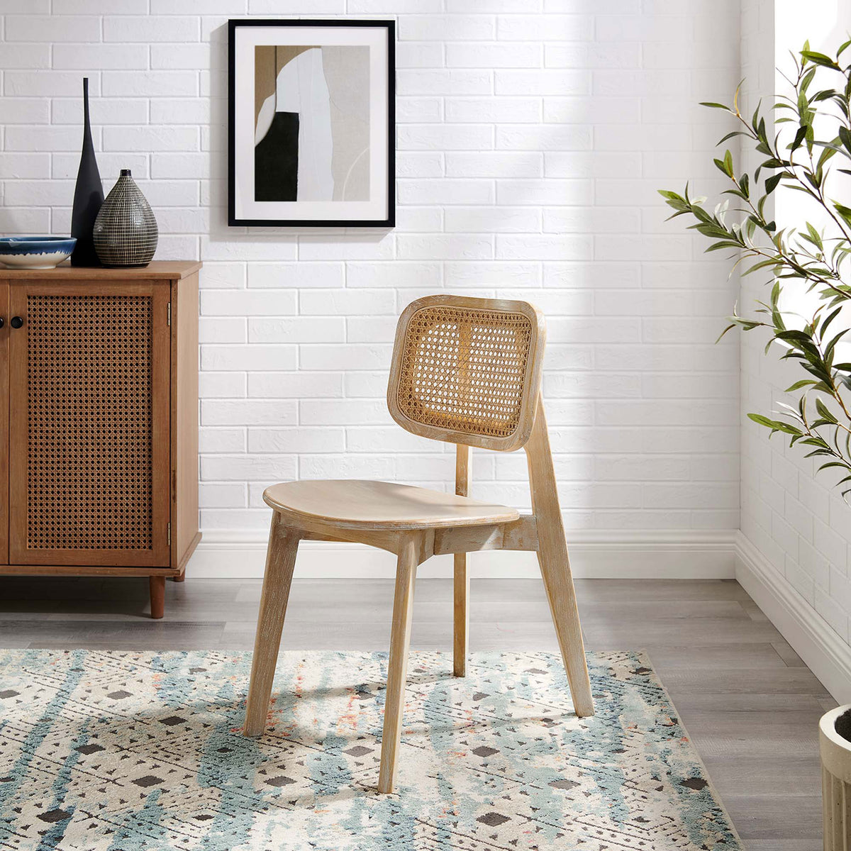 Cane back wood dining chair styled in a modern living space with rug, cabinet, and artwork || EEI-4645-GRY || front_angle_room