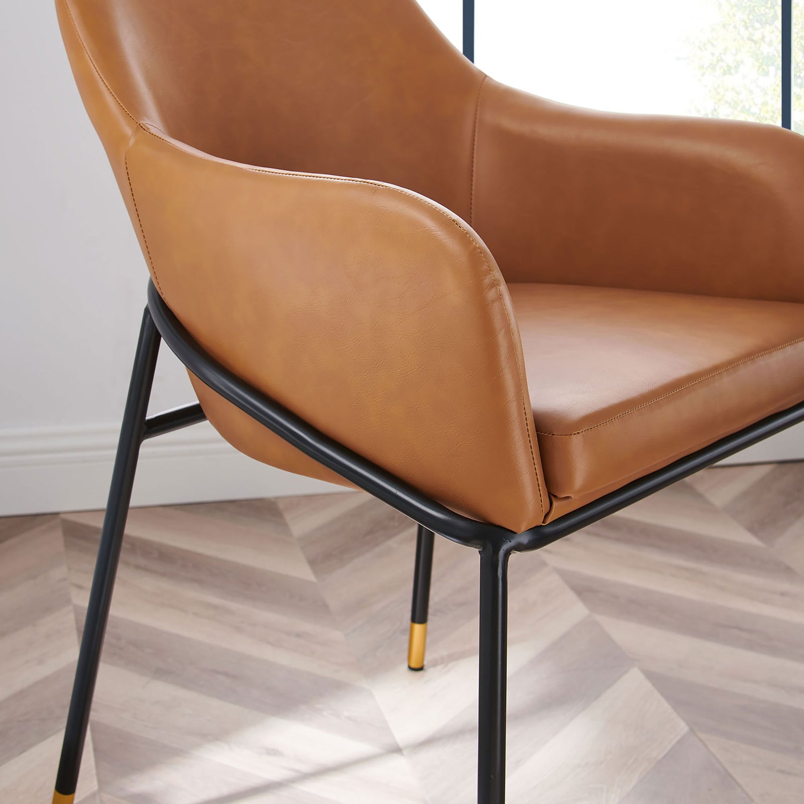 Tan vegan leather upholstery with smooth curves, padded seat, and slim black frame in a modern room || EEI-4672-BLK-TAN || detail_room