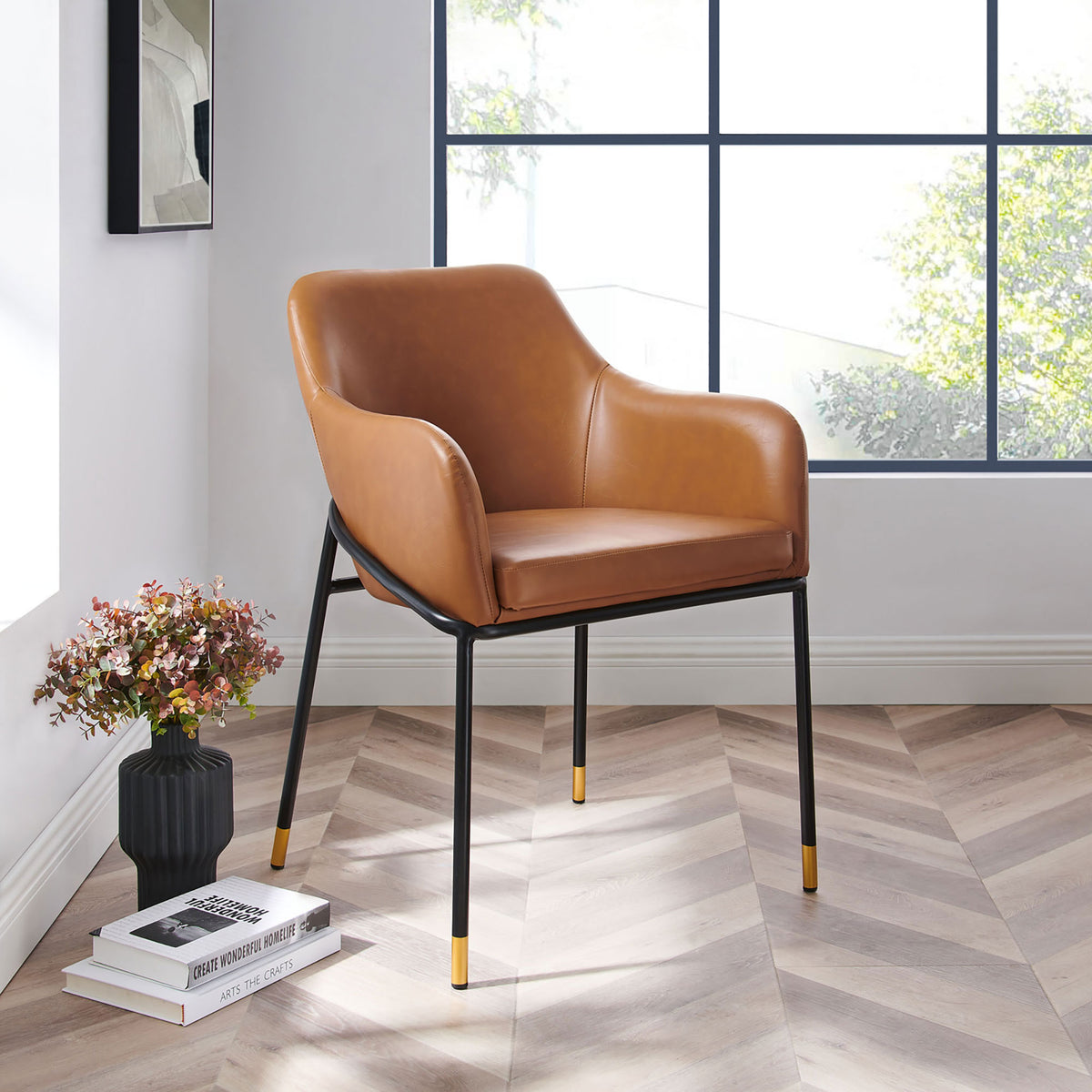 Jovi tan vegan leather dining chair styled in a sunlit room with herringbone wood floors || EEI-4672-BLK-TAN || front_angle_room