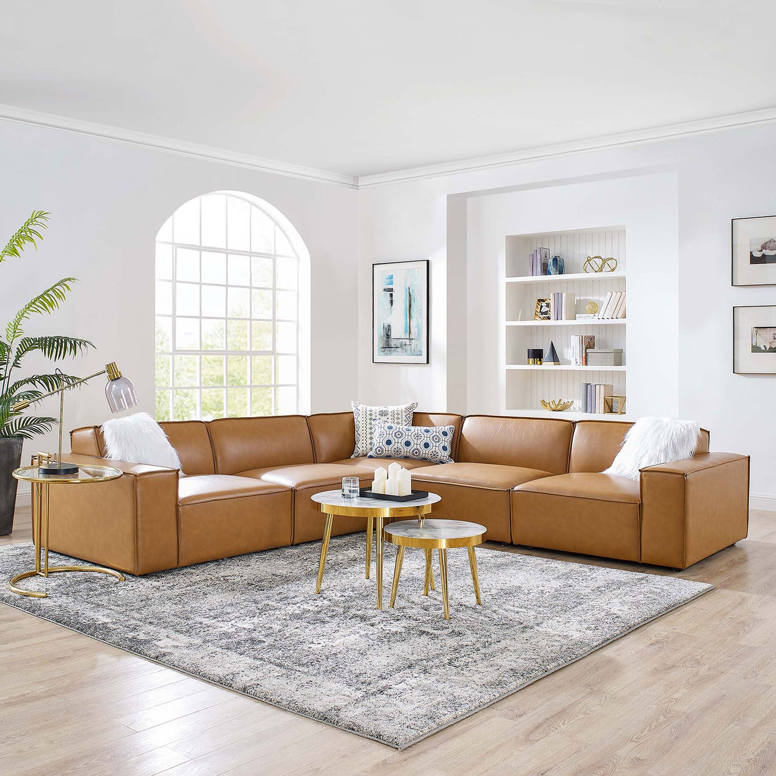 Spacious tan vegan leather sectional anchoring a light-filled living room with gray rug and gold accent tables || EEI-4712-TAN || front_angle_room