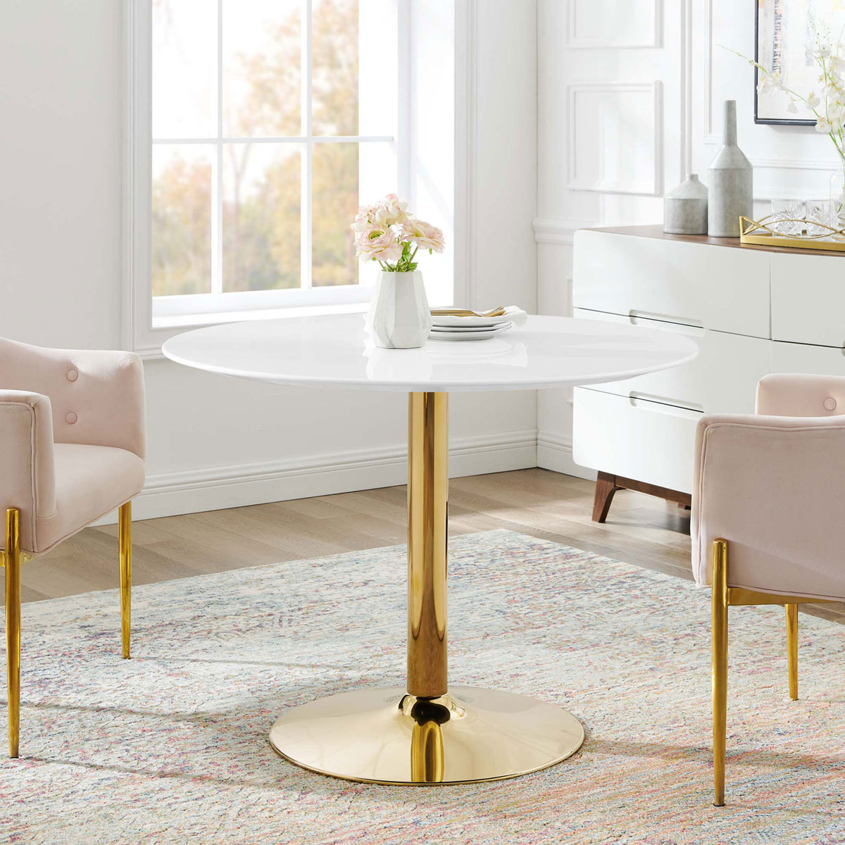 Verne 40-inch round dining table styled with blush chairs and rug in a bright modern space || EEI-4748-GLD-WHI || front_room
