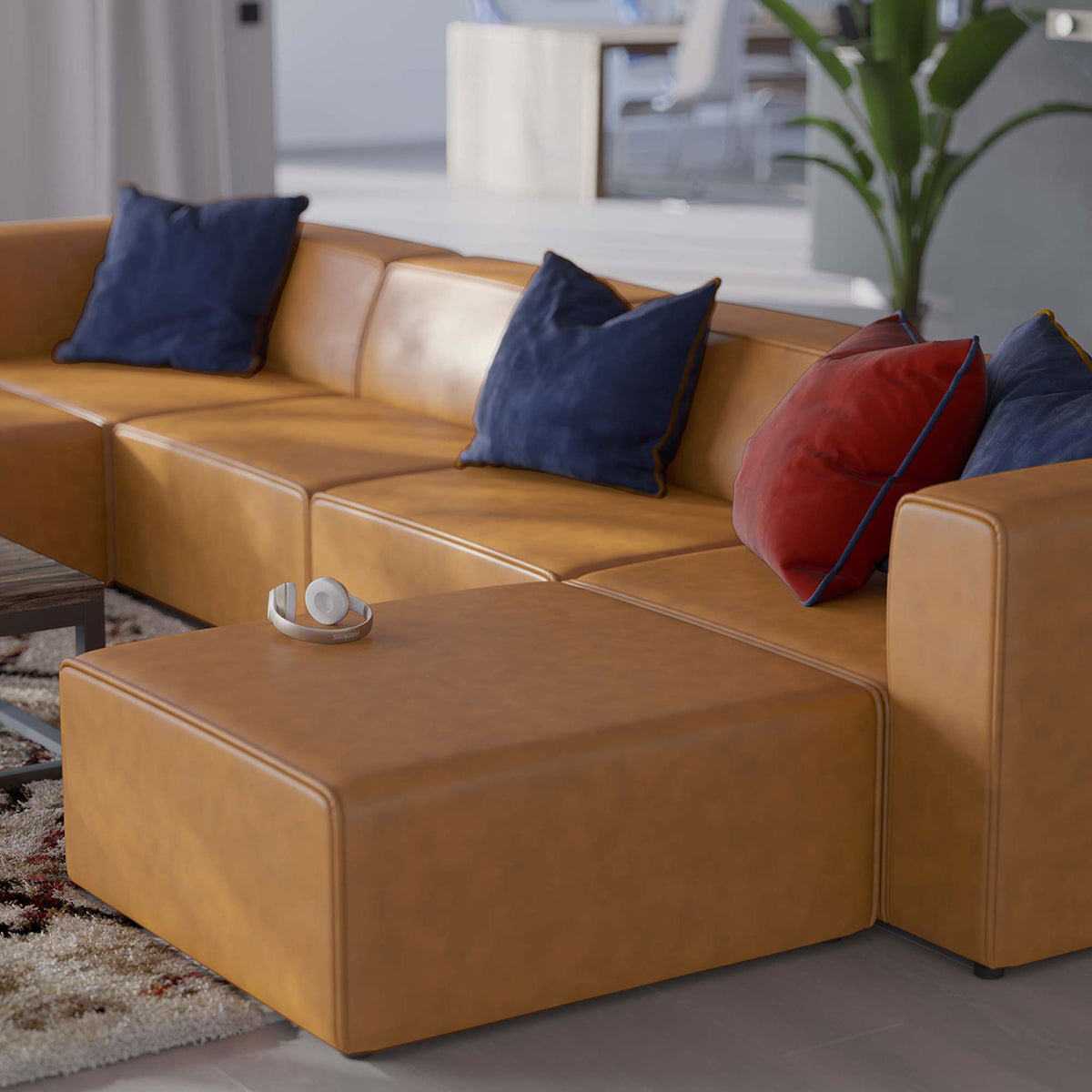 Ottoman and sofa section in tan vegan leather topped with colorful accent pillows in a bright, airy room || EEI-4794-TAN || front_angle_partial_room