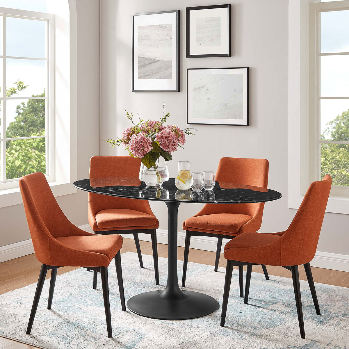 Black oval pedestal dining table with orange upholstered chairs in a bright contemporary dining room || EEI-4881-BLK-BLK || front_angle_room