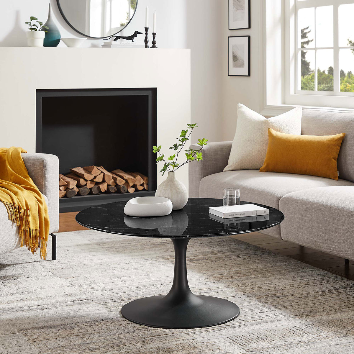 Mid-century round coffee table anchoring a living room with black marble-look top and pedestal base || EEI-4884-BLK-BLK || front_angle_room