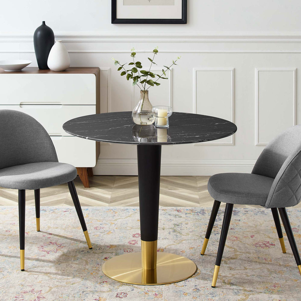 Large round black artificial marble dining table arranged with gray chairs in an elegant dining room || EEI-5132-GLD-BLK || front_angle_room