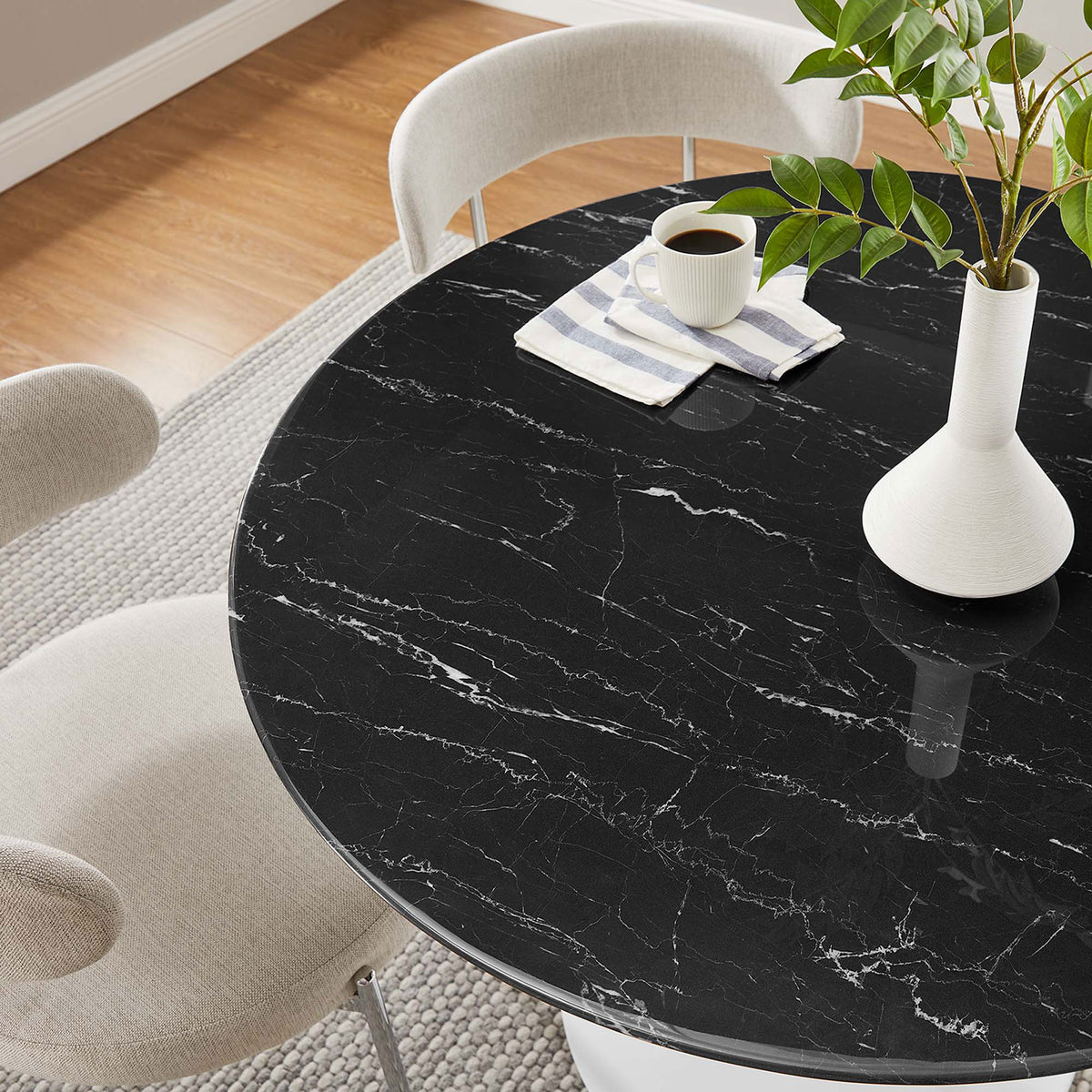 Black faux marble tabletop styled with coffee and greenery for an inviting modern dining setting || EEI-5181-WHI-BLK || detail_room