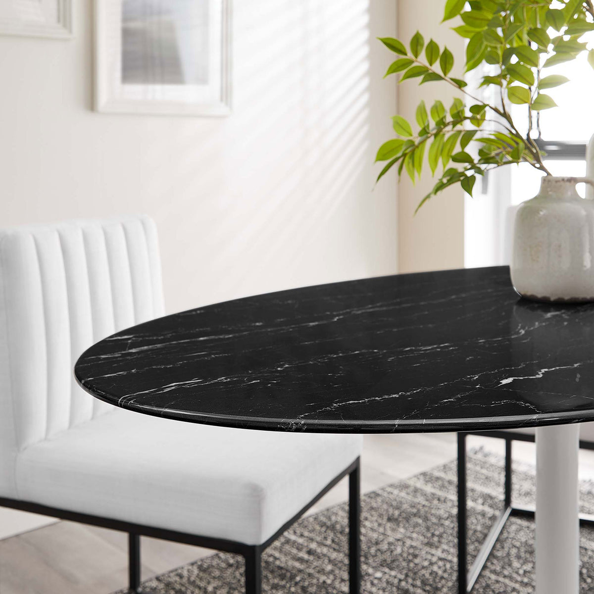 Black faux marble tabletop of the Lippa 54 in. dining table styled with modern white chairs in a bright room || EEI-5185-WHI-BLK || detail_room