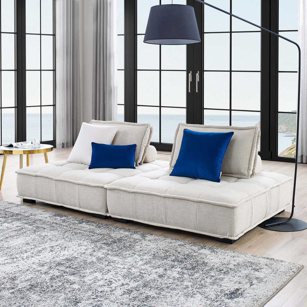 Beige Saunter loveseat creates a cozy lounge centerpiece with tufted seat cushions and bolster pillows. || EEI-5204-BEI || front_angle_multi_room