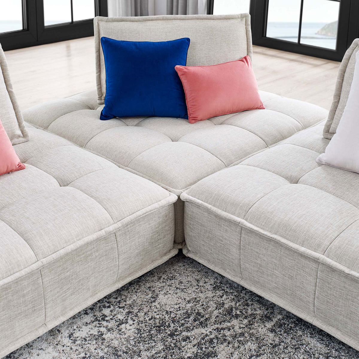 Tufted seat platforms of the Saunter beige sofa joined together with colorful accent pillows || EEI-5206-BEI || detail_room