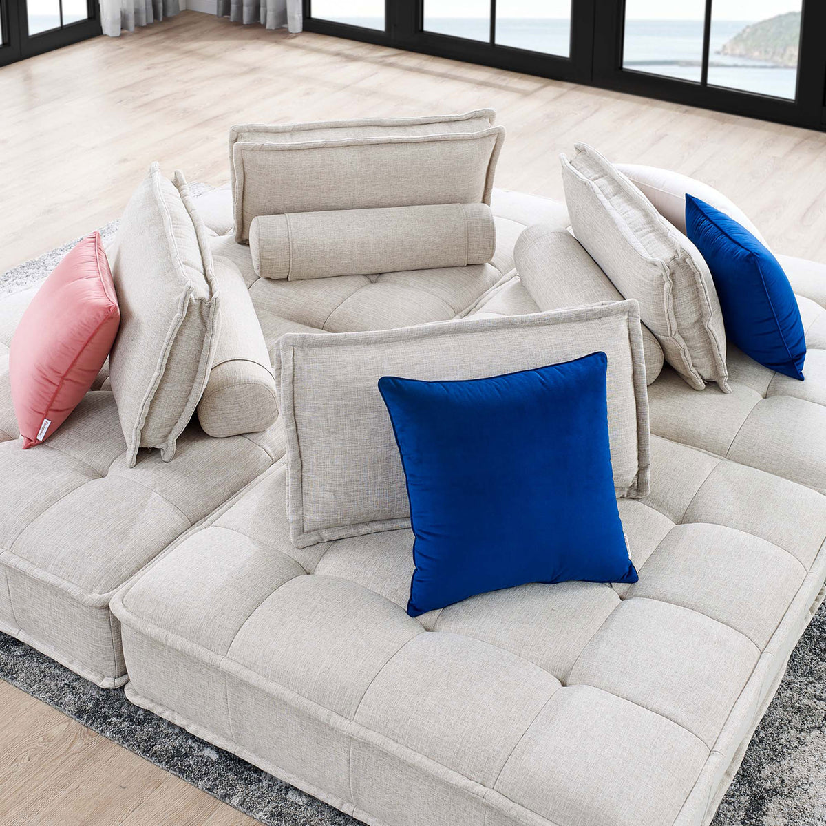 Square modular sectional creates a cozy conversation hub on a gray rug, styled with colorful accent pillows || EEI-5208-BEI || detail_room