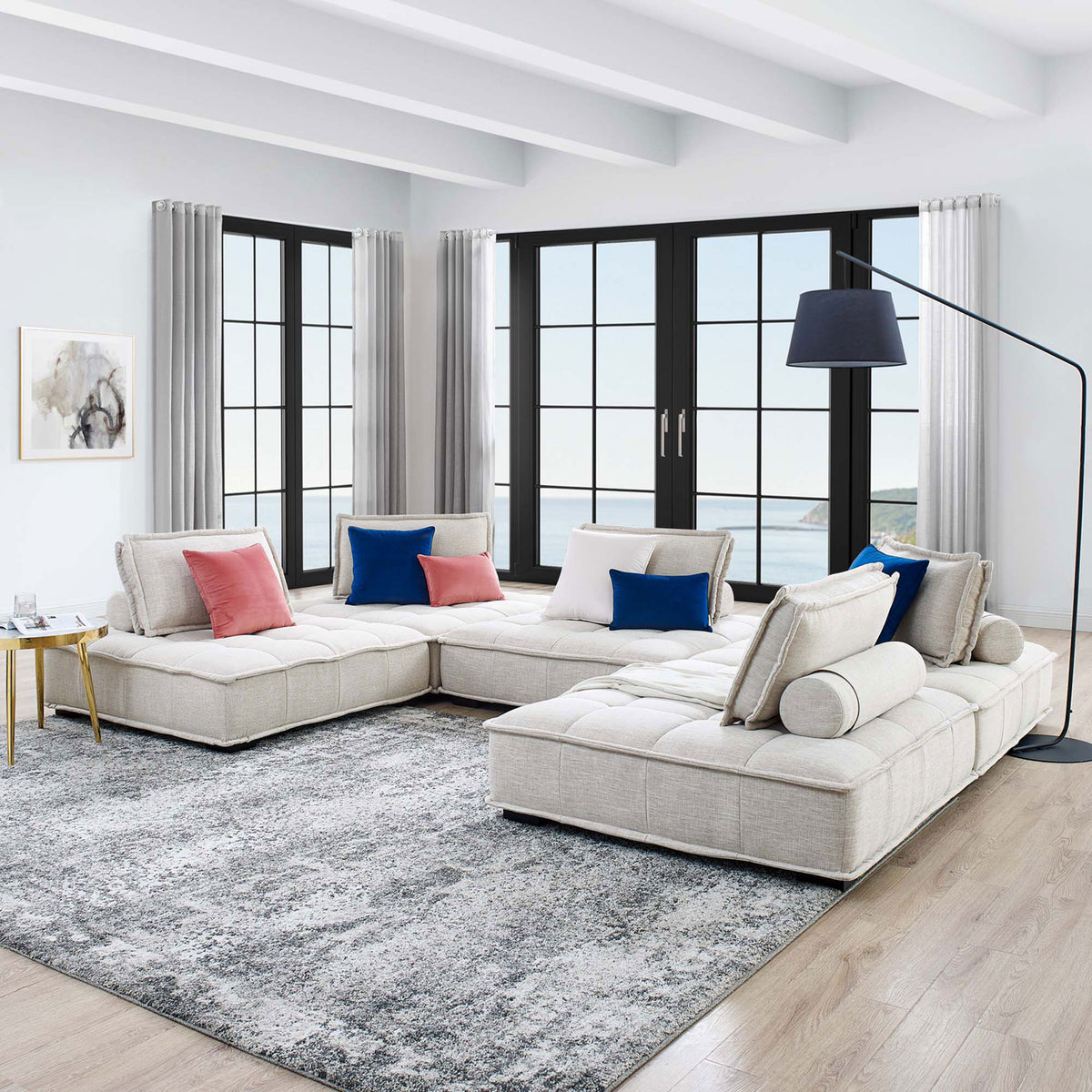 Modern living room scene featuring the beige Saunter sectional with tufted seats and layered accent pillows || EEI-5210-BEI || front_angle_room