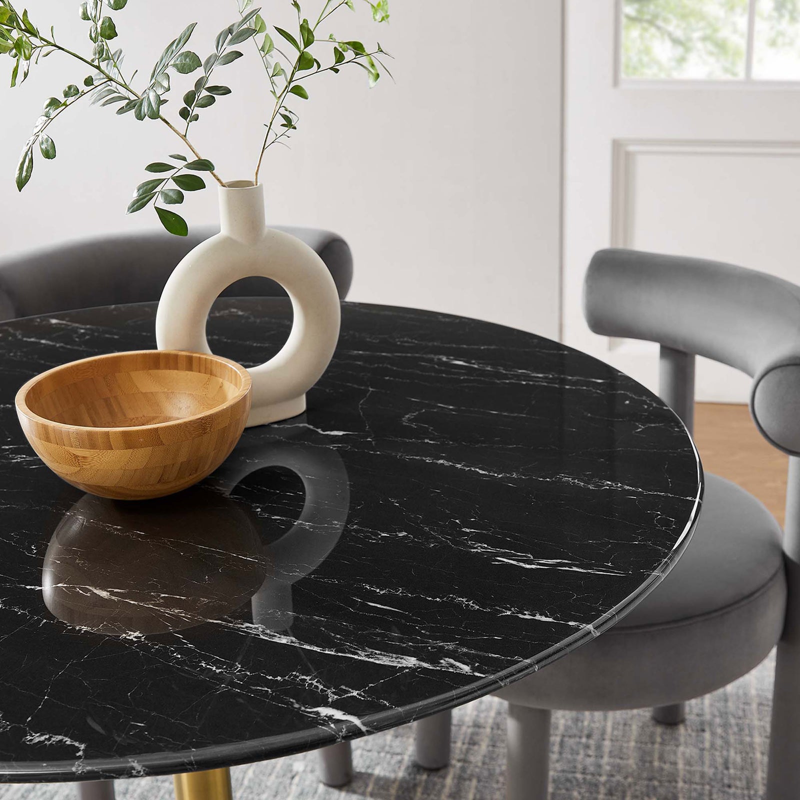 Black faux marble tabletop styled with sculptural vase and bowl to emphasize its rich veining detail || EEI-5238-GLD-BLK || detail_room