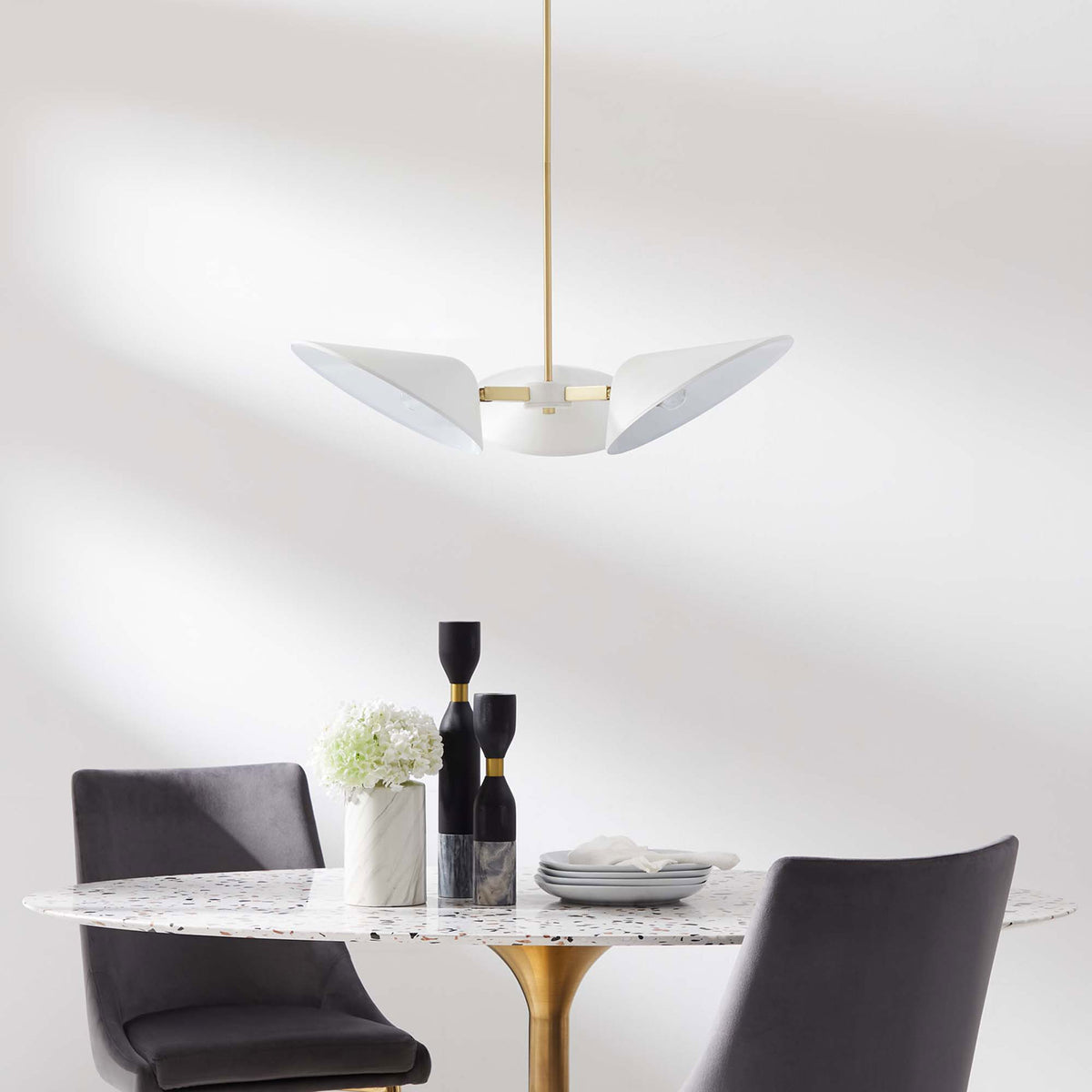 Modern pendant crowns a dining nook with crisp white shades and warm brass accents || EEI-5299-WHI || front_room