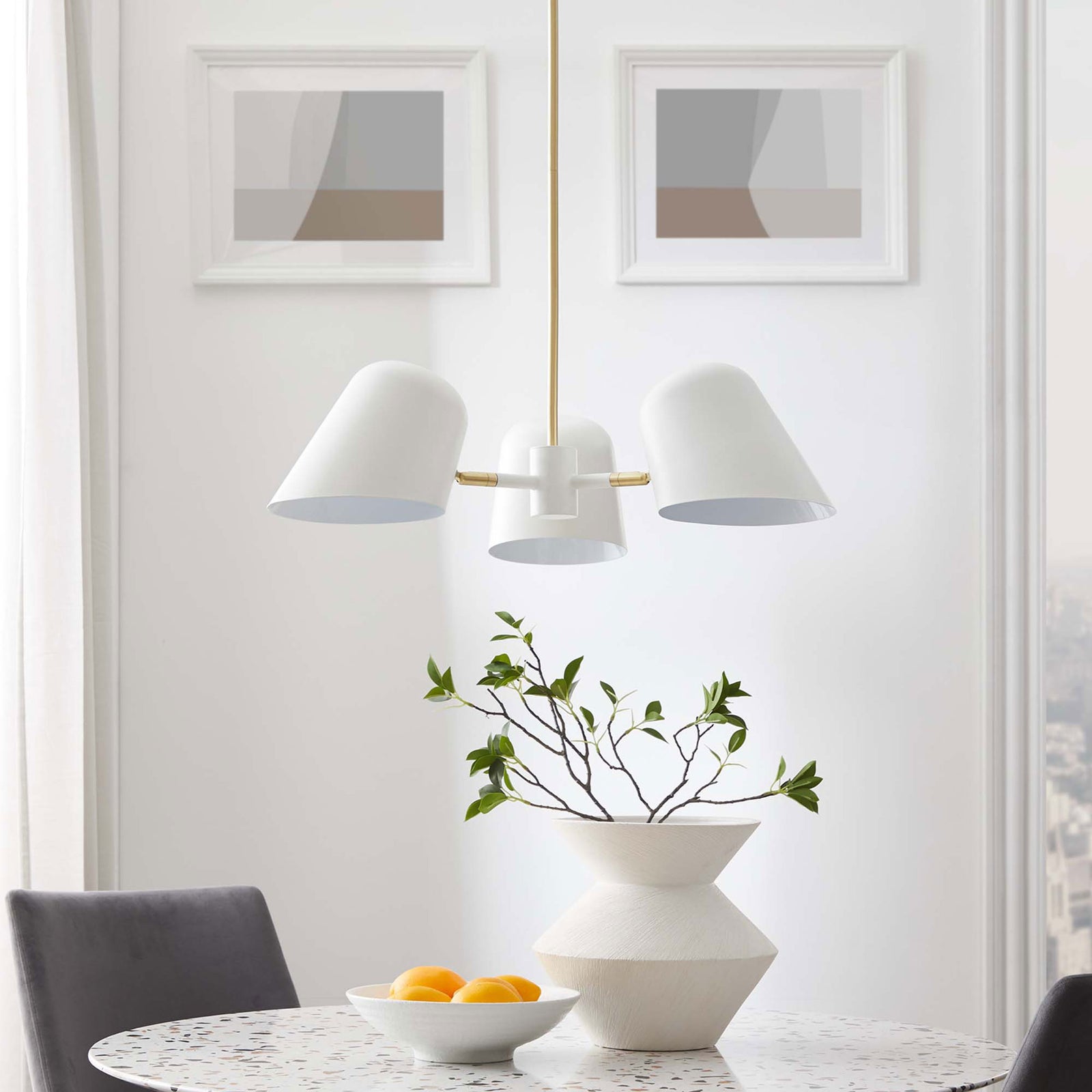 Sculptural pendant elevates dining decor with crisp white shades and warm brass details || EEI-5301-WHI || front_room