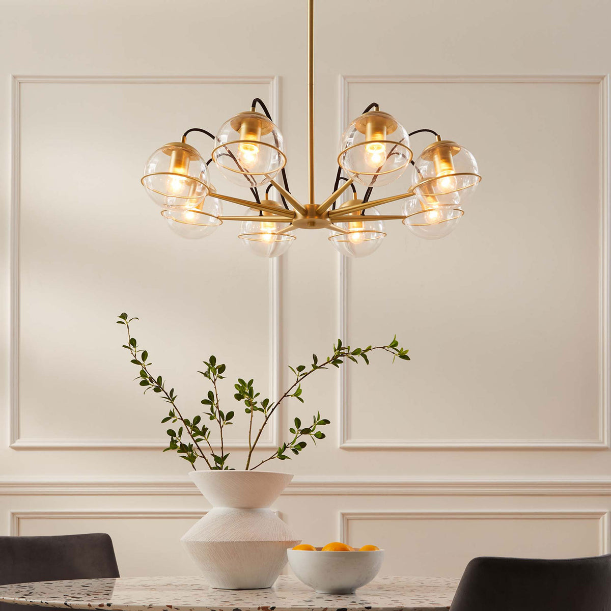 Glowing glass globes illuminate the room with soft, inviting light and satin brass warmth || EEI-5307-CLR-GLD || front_on_room