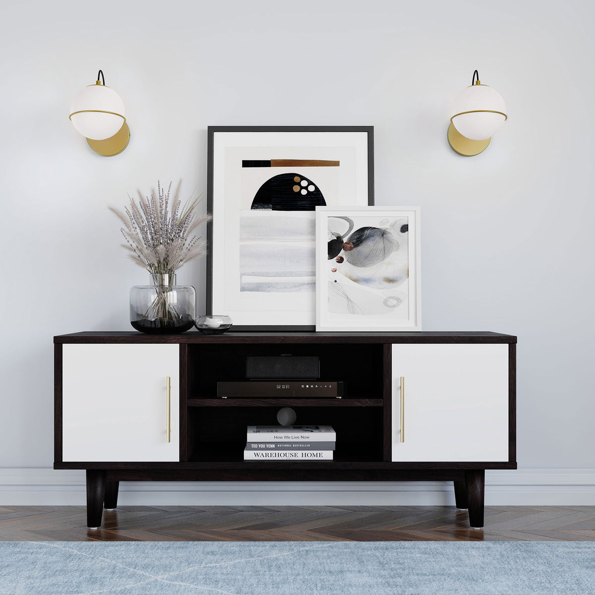 Pair of opal globe wall sconces in satin brass flanking modern artwork above a dark console || EEI-5308-OPA-GLD || front_room