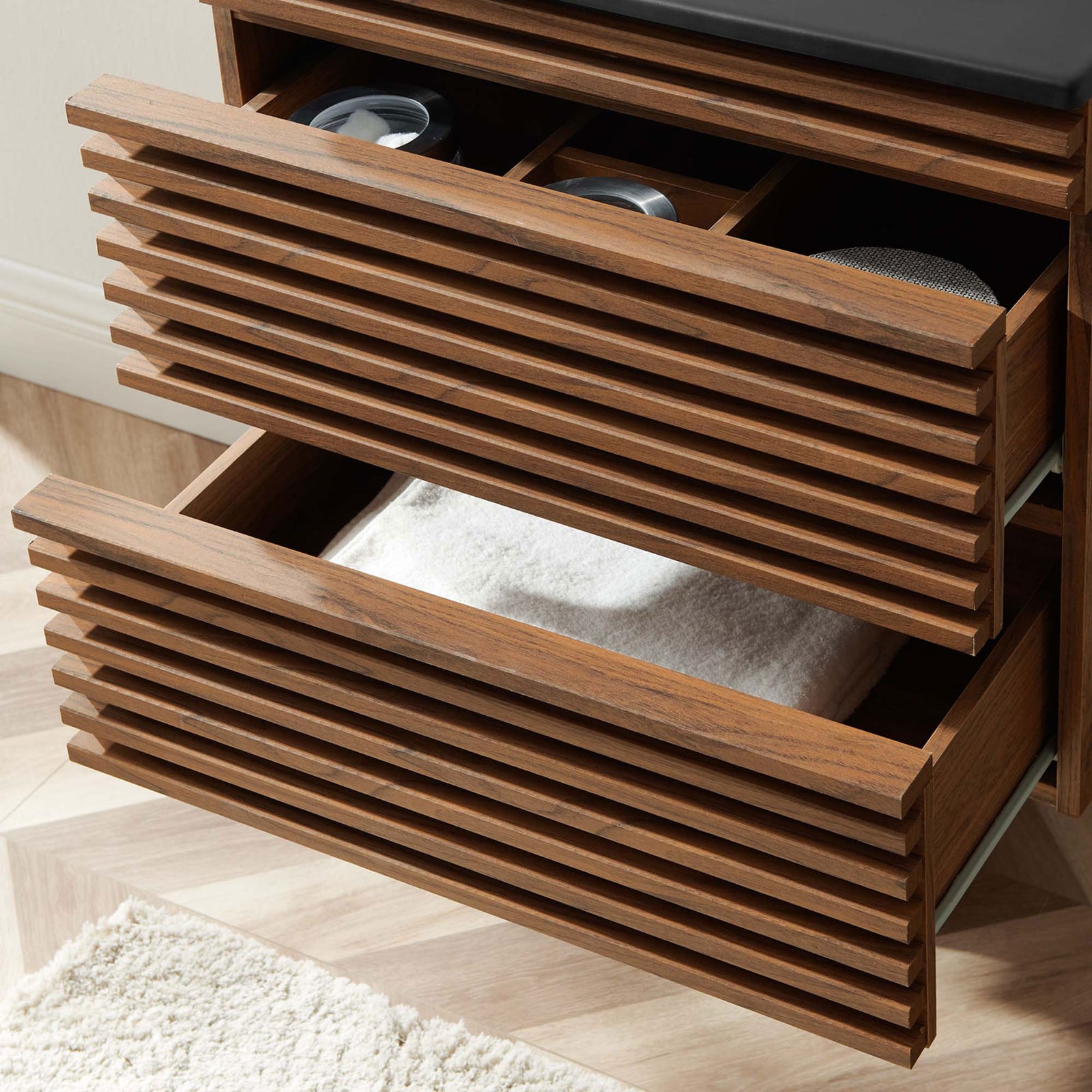 Open drawers reveal organized storage for bath essentials beneath the integrated sink. || EEI-5364-WAL-BLK || storage_open_room