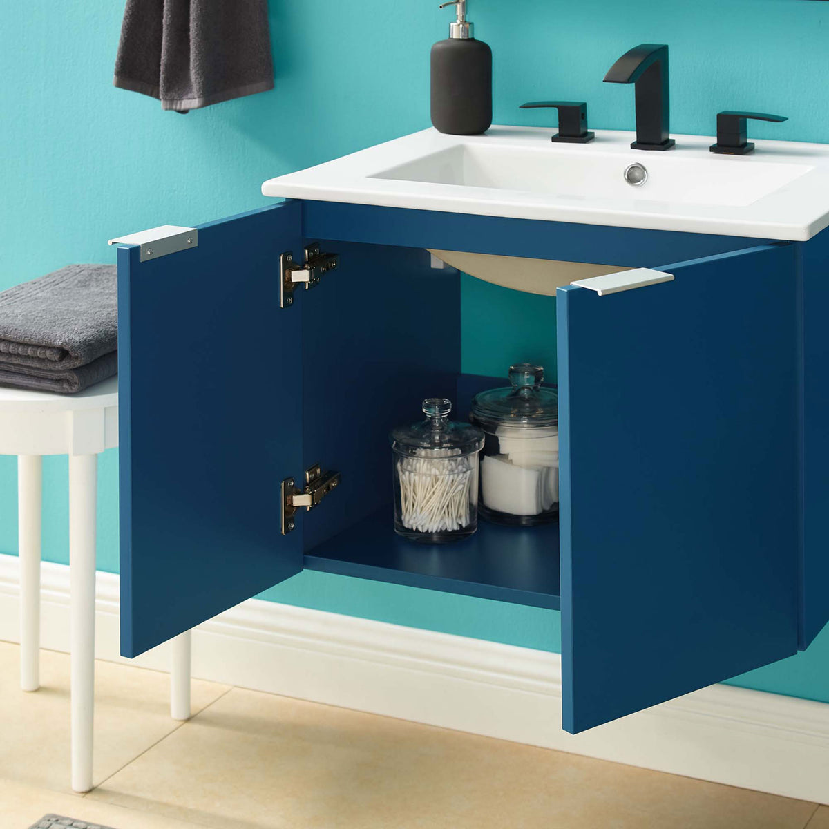 Wall-mounted vanity in navy with doors open to show roomy shelf storage || EEI-5379-NAV-WHI || front_open_room