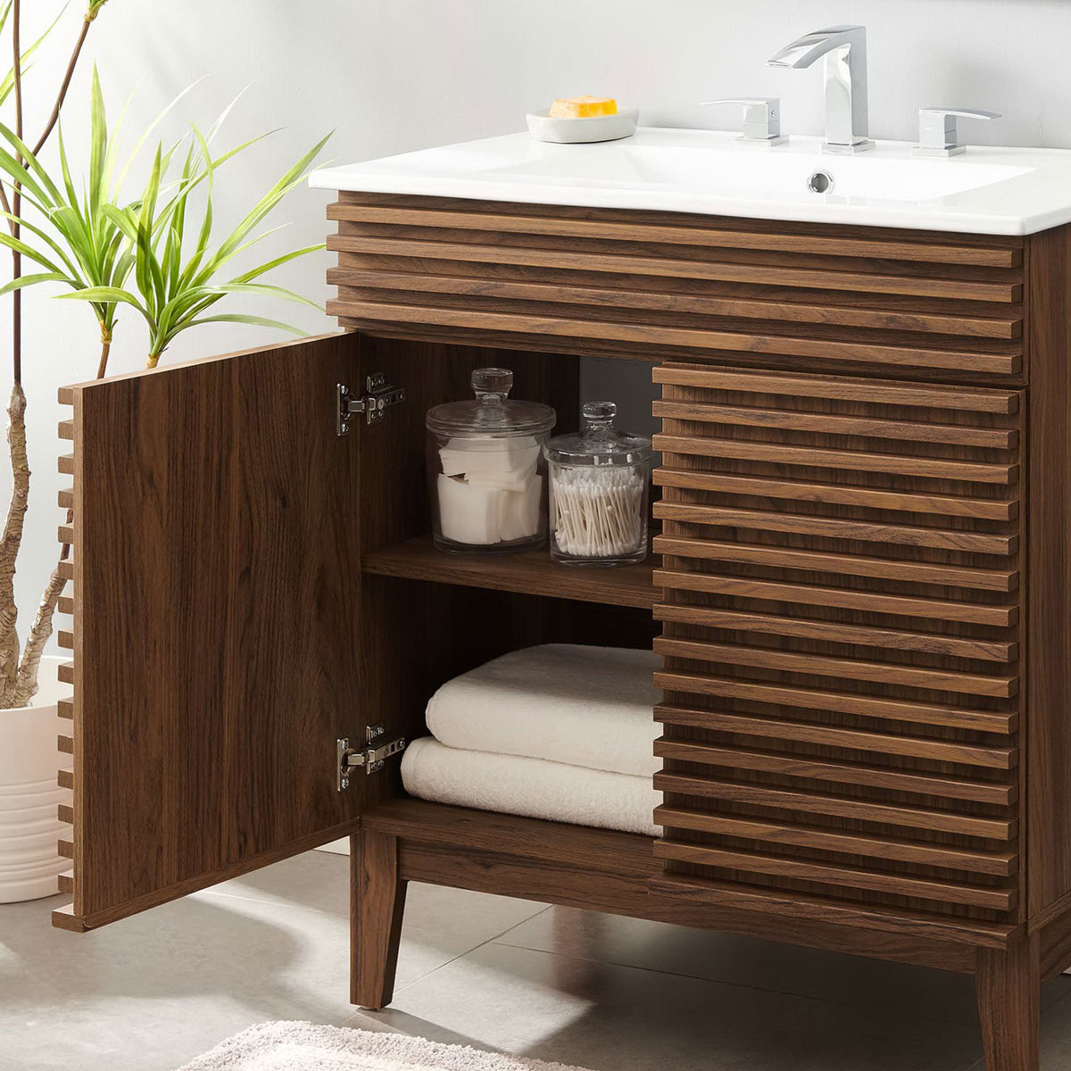 Open cabinet displays neatly organized towels and toiletries on the interior shelf. || EEI-5422-WAL-WHI || storage_open_room