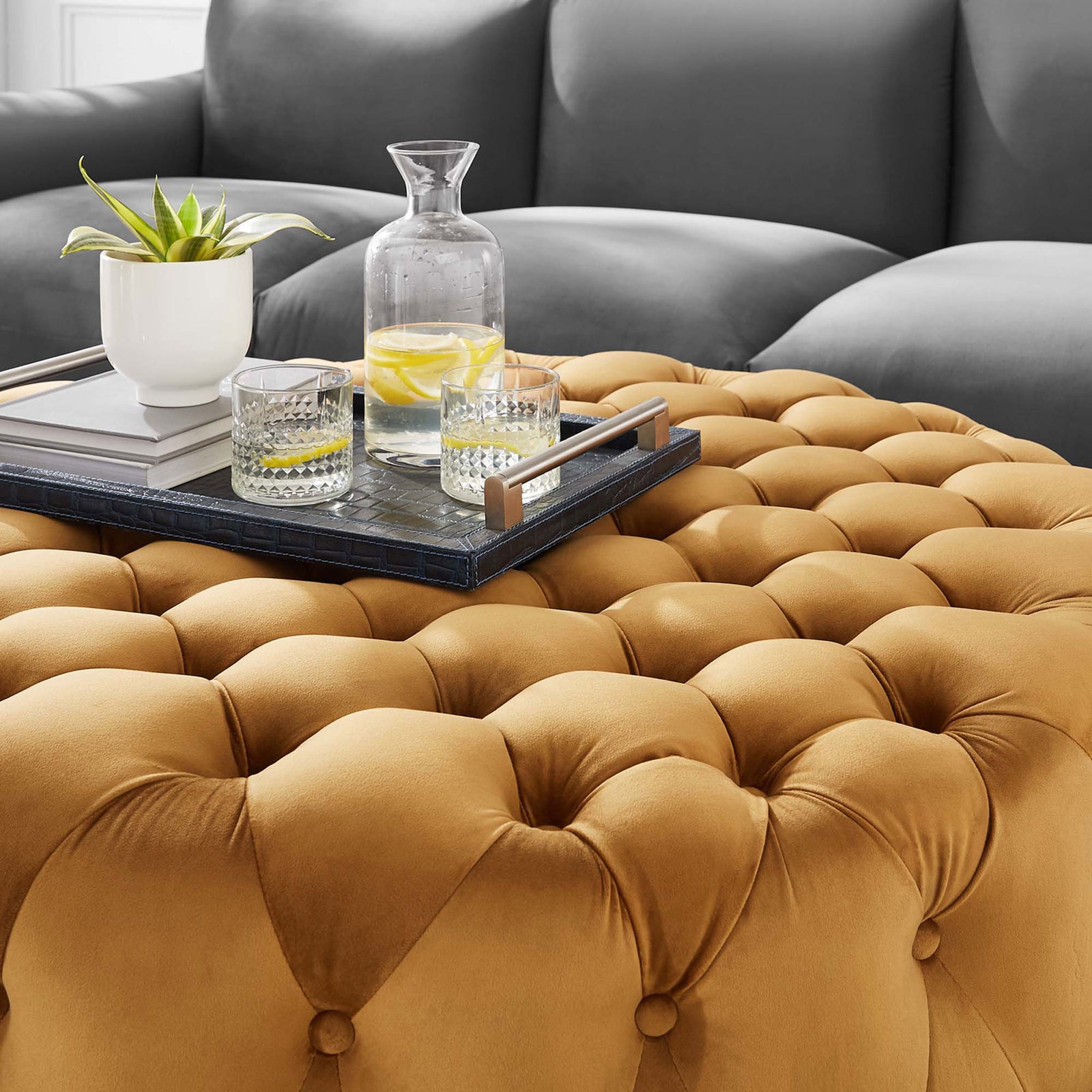 Tufted cognac velvet ottoman styled with a tray and drinks to create a plush coffee table centerpiece || EEI-5469-COG || detail_room