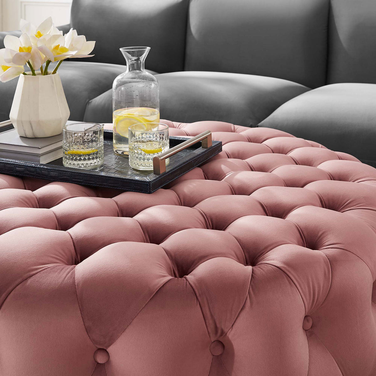 Dusty rose velvet ottoman used as a stylish coffee table with tray, drinks, and fresh flowers || EEI-5469-DUS || detail_room