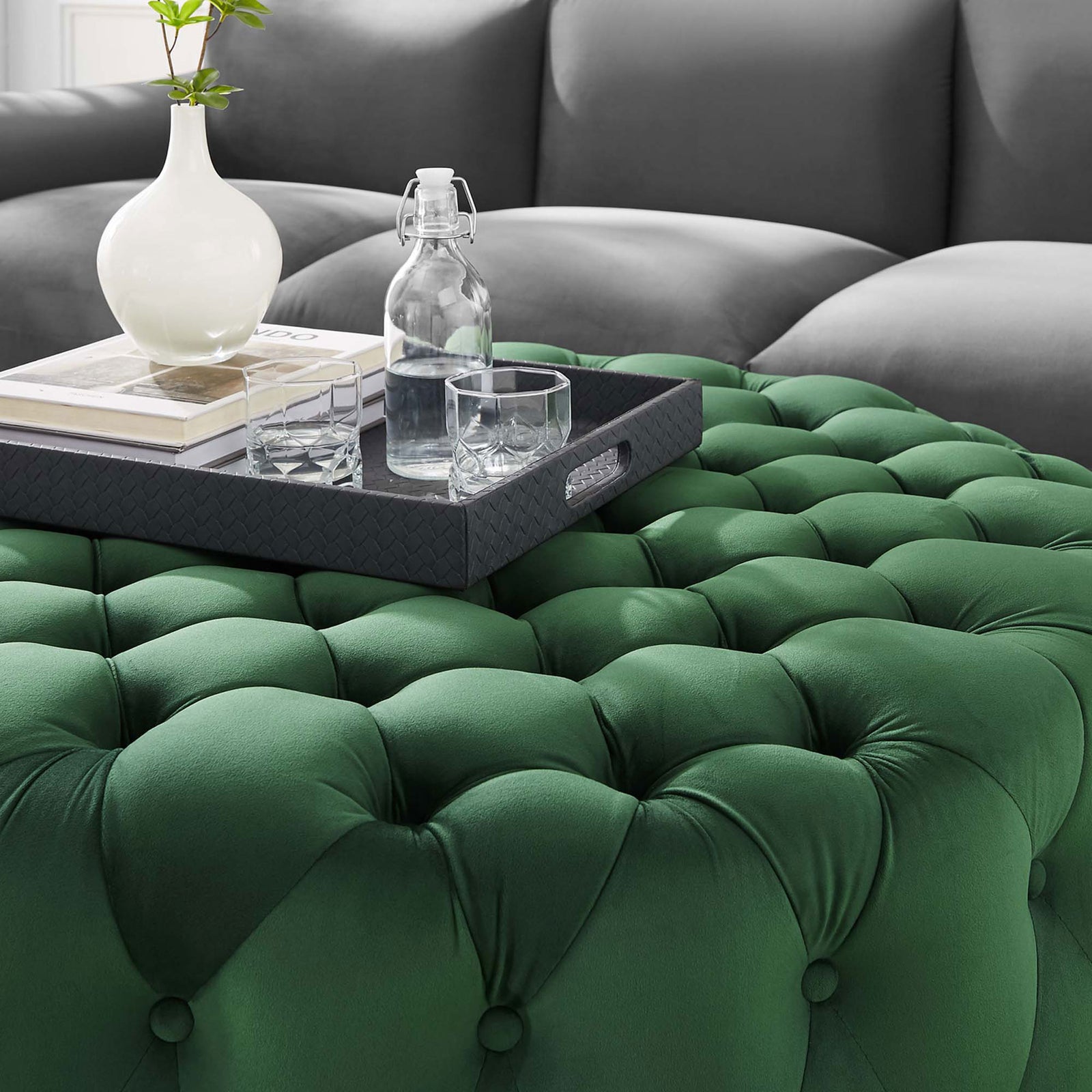 Tufted emerald velvet ottoman surface styled with a tray, vase, and glasses for entertaining || EEI-5469-EME || detail_room