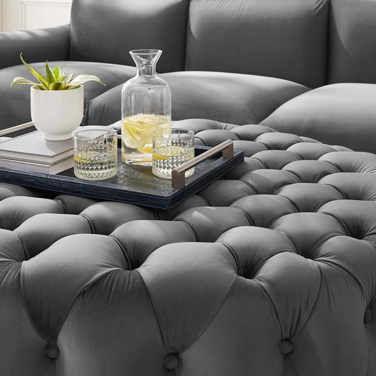 Tufted gray velvet ottoman topped with a tray, drinks, and decor, adding soft texture and function to the living room || EEI-5469-GRY || detail_room