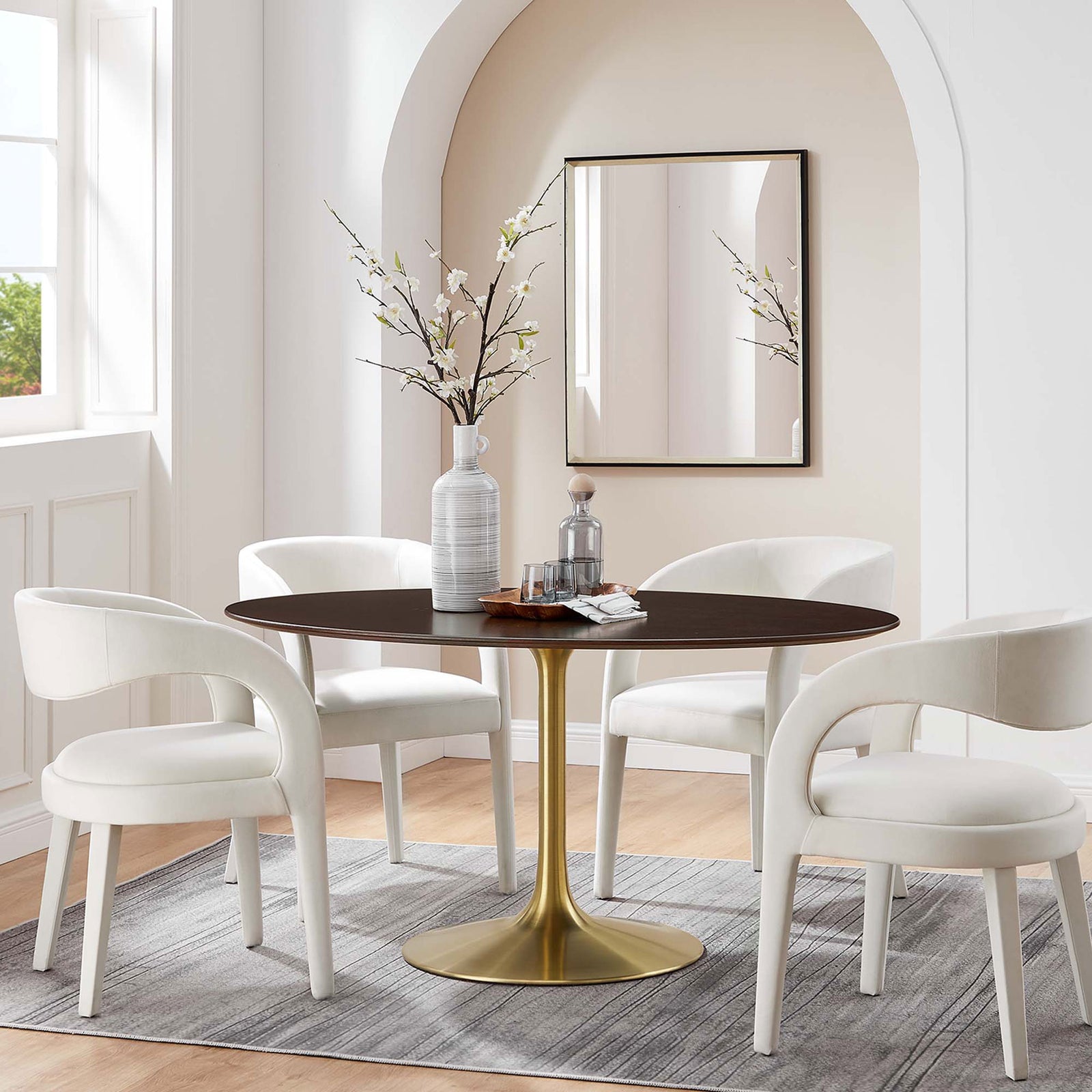 Walnut pedestal dining table styled with four ivory chairs in a bright contemporary dining nook || EEI-5524-GLD-CHE || front_angle_room