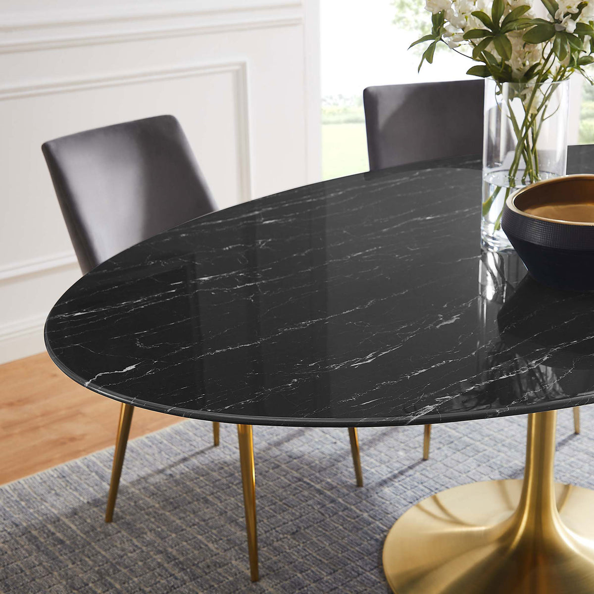 Glossy black faux marble tabletop with decor accents in an elegant light-filled dining room. || EEI-5528-GLD-BLK || detail_room