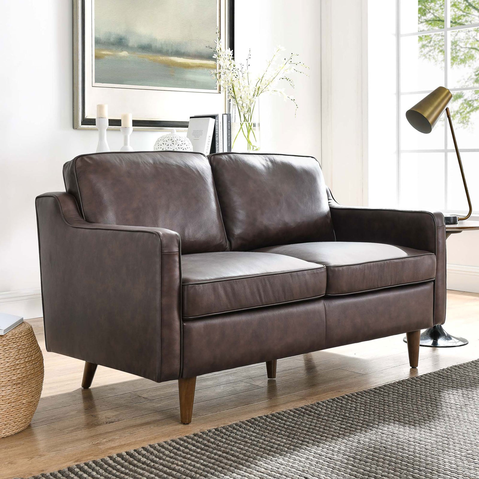 Brown genuine leather loveseat styled in a bright living room with rug, lamp, and wall art || EEI-5554-BRN || front_angle_room