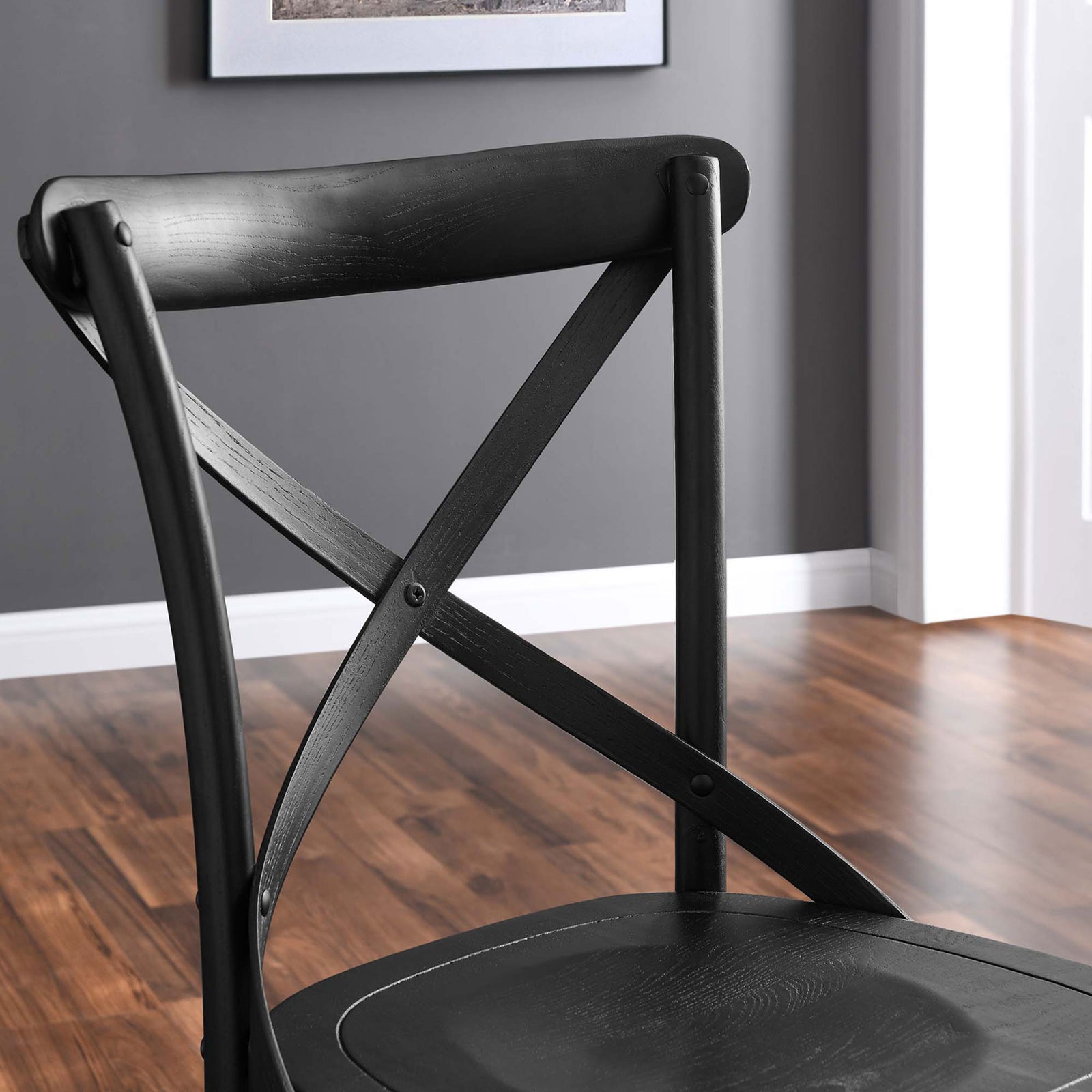 Elm wood X-back on black dining chair against gray wall and hardwood floor || EEI-5564-BLK || detail_room