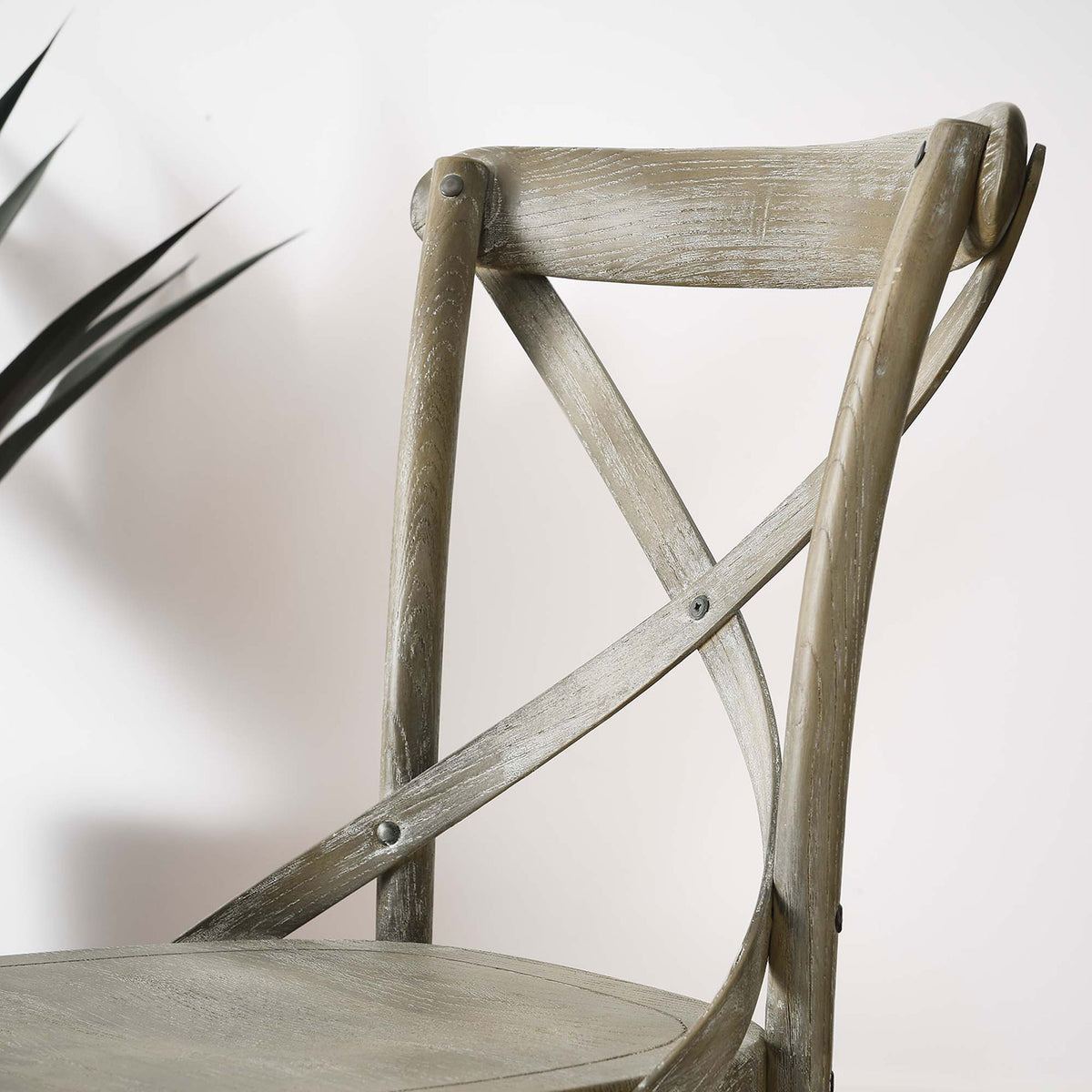 Gray cross-back chair in a modern dining room highlighting the curved backrest detail || EEI-5564-GRY || detail_room