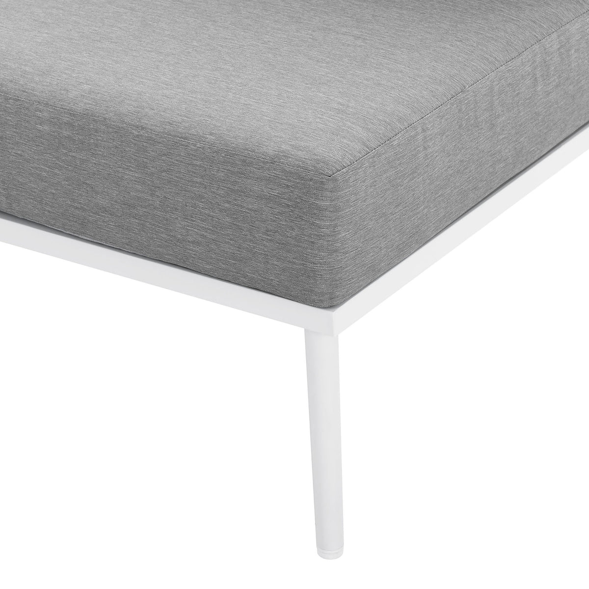Corner of the gray cushion and slim white leg on the Stance outdoor armless chair || EEI-5568-WHI-GRY || leg_studio