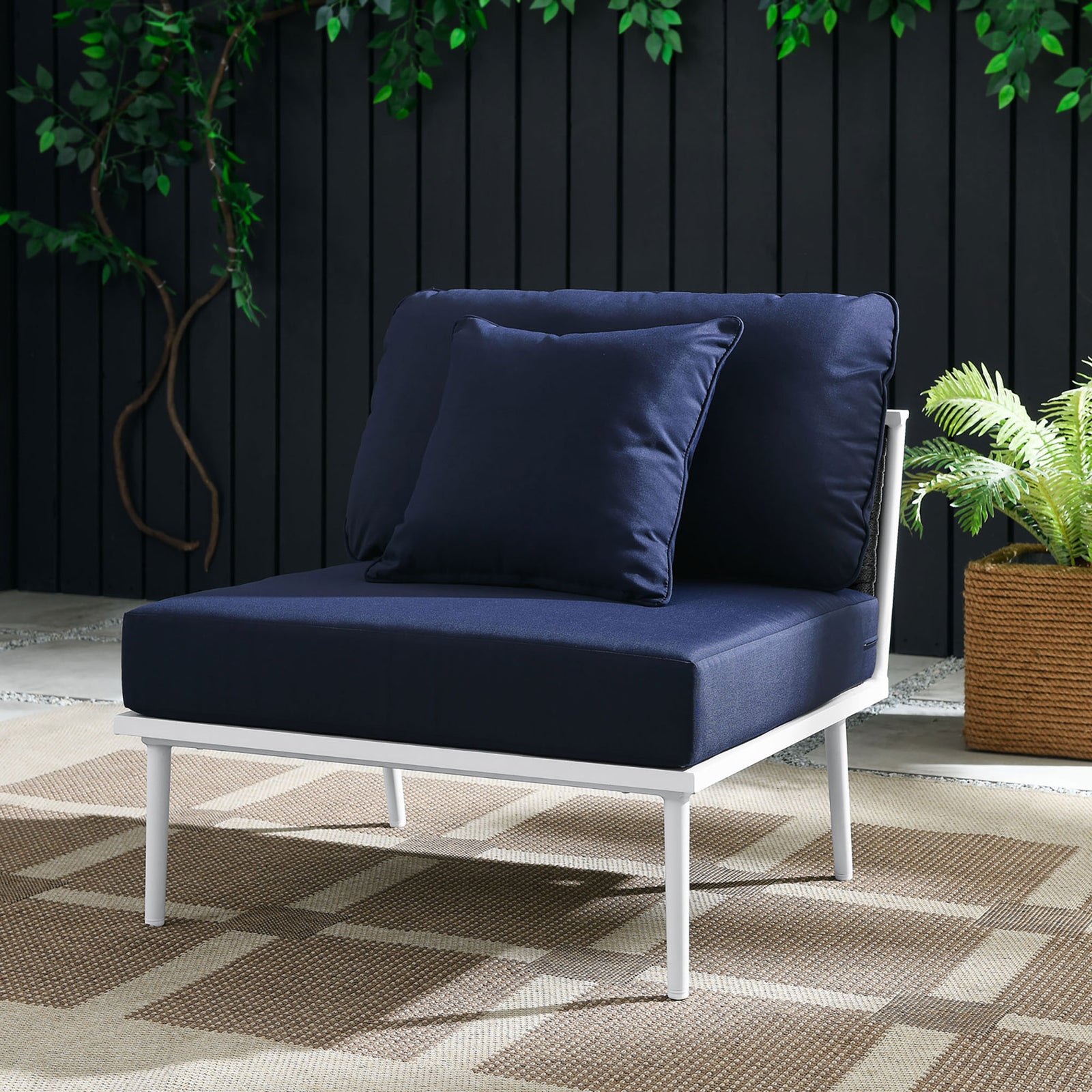 Navy Stance armless chair with white frame styled on a patio with greenery and woven rug || EEI-5568-WHI-NAV || front_angle_room