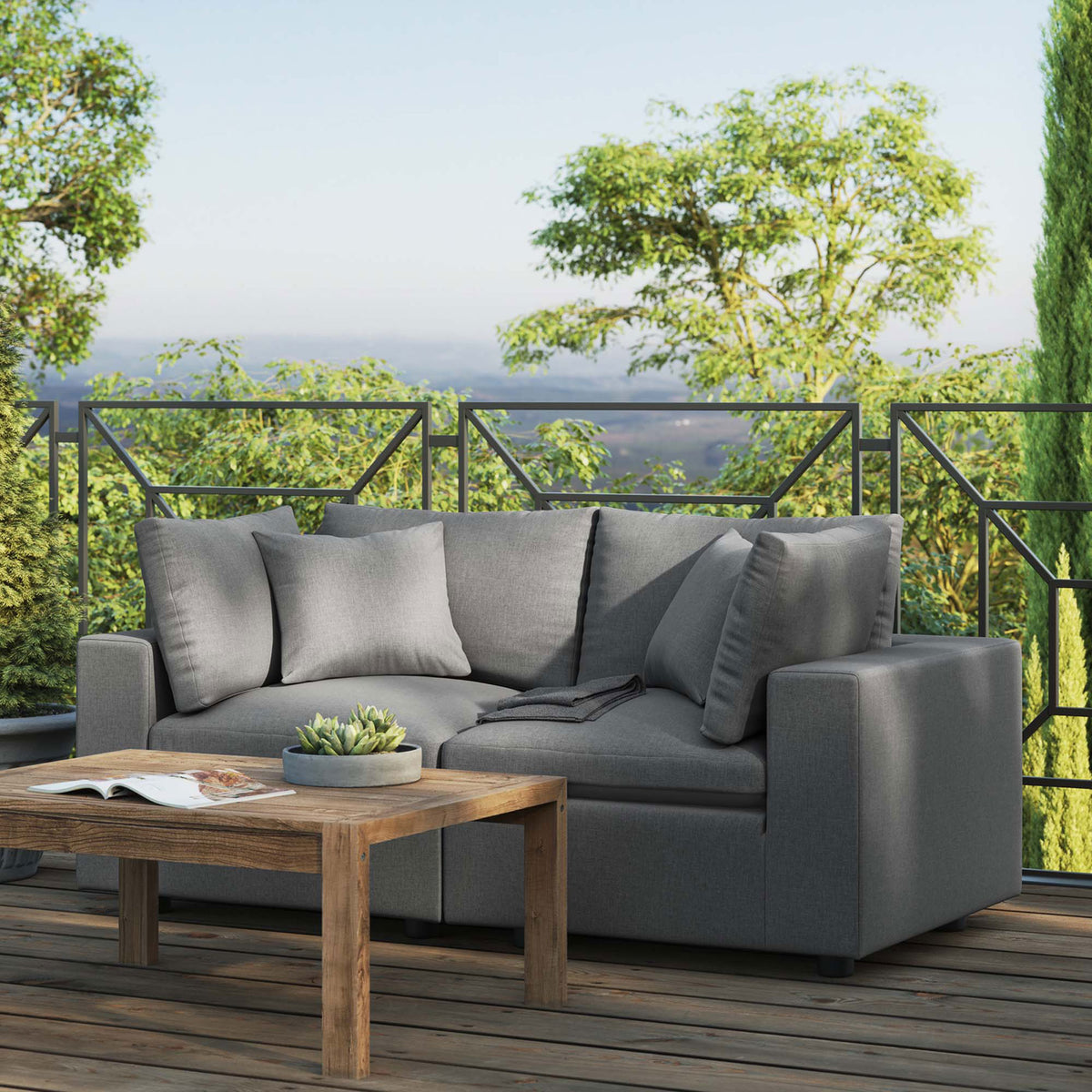 Charcoal outdoor loveseat on a spacious deck with lush greenery and rustic coffee table || EEI-5576-CHA || front_angle_room