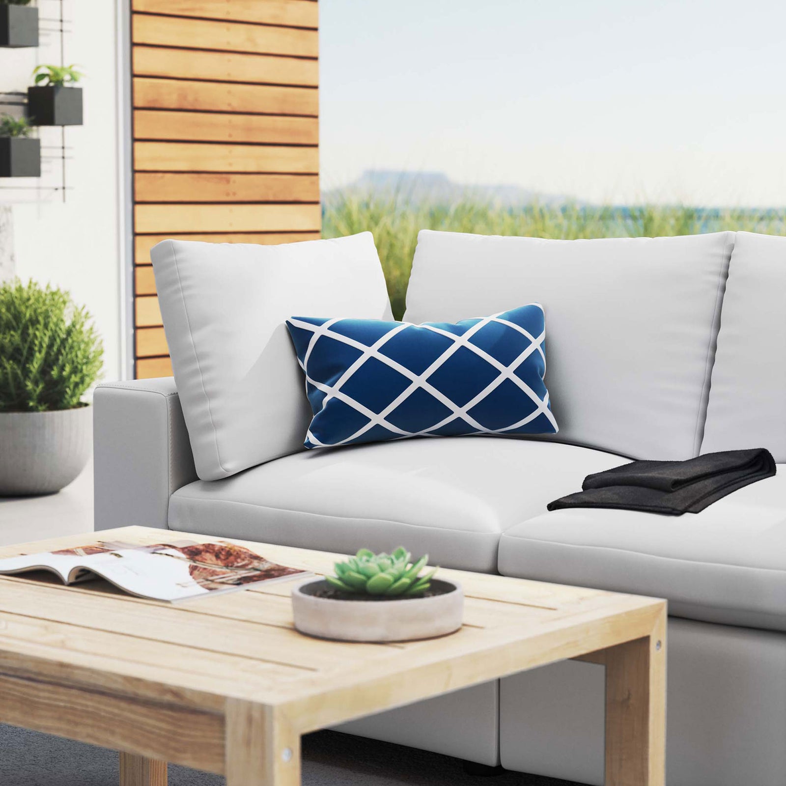 White patio loveseat styled with a wood coffee table and blue accent pillow on a modern terrace || EEI-5577-WHI || detail_room