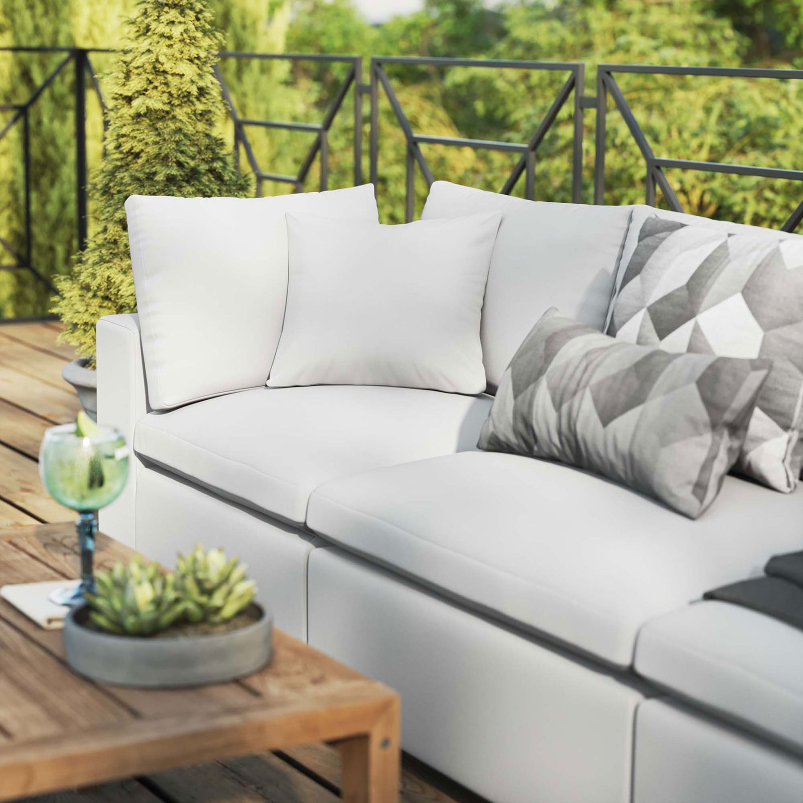 White outdoor sofa styled with accent pillows, greenery, and a rustic wood coffee table on a deck || EEI-5578-WHI || detail_room