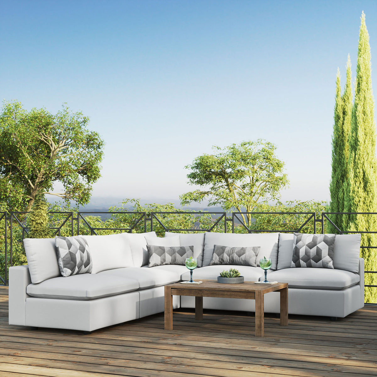 White Commix outdoor sectional creating an airy lounge on a sunny terrace with lush views. || EEI-5587-WHI || front_angle_room