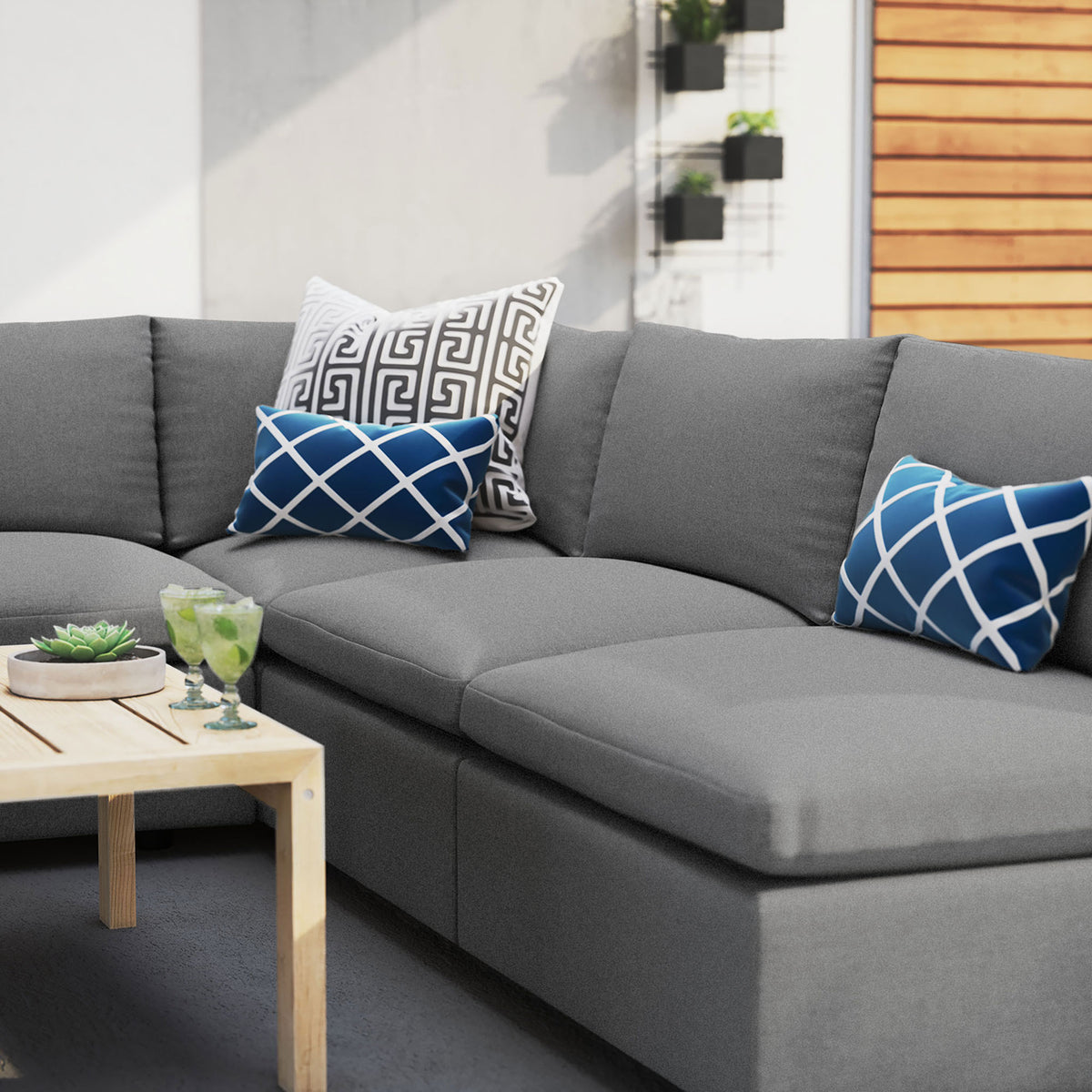 Gray Sunbrella outdoor sectional styled with bold blue accent pillows on a modern patio. || EEI-5588-SLA || detail_room