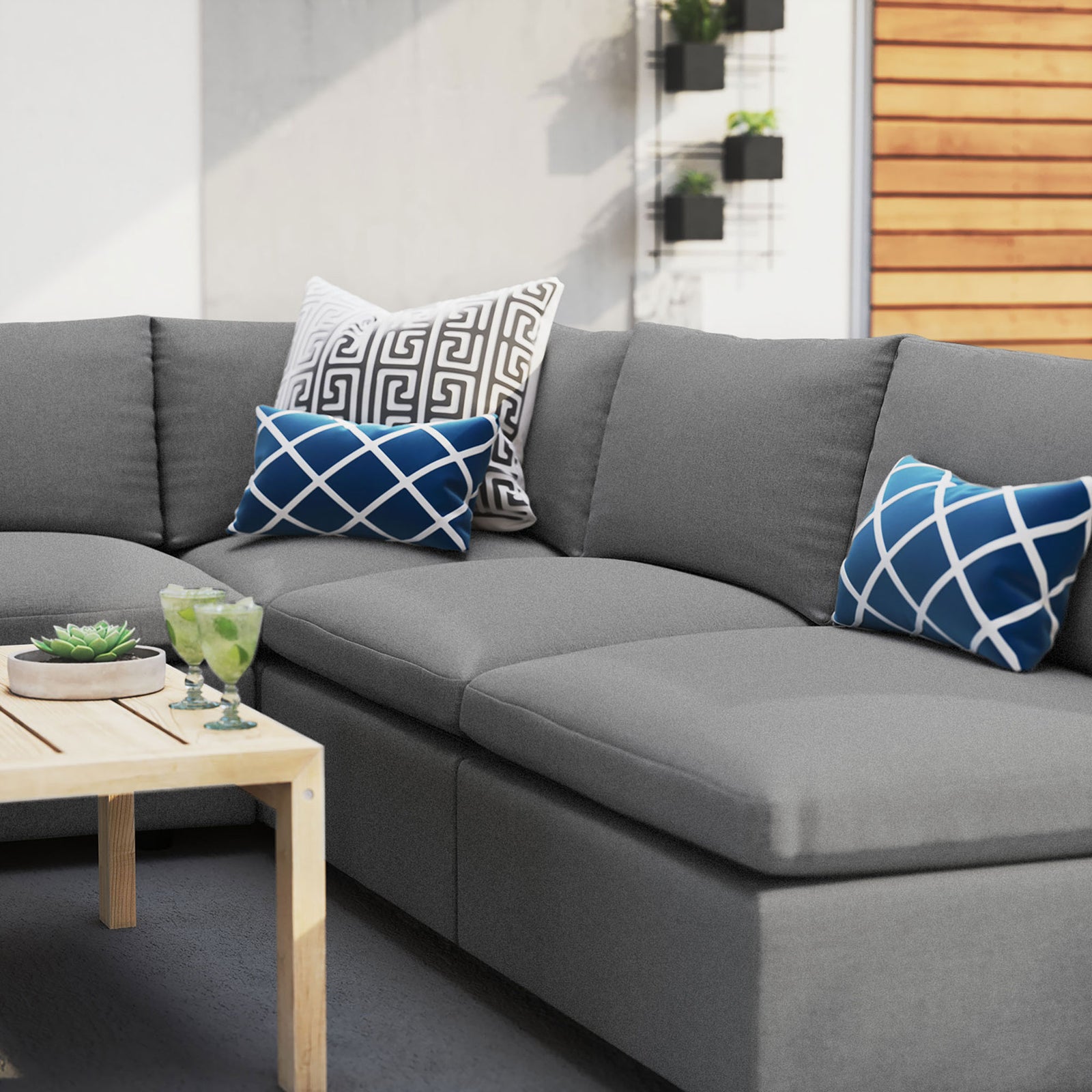 Gray Sunbrella outdoor sectional styled with bold blue accent pillows on a modern patio. || EEI-5588-SLA || detail_room