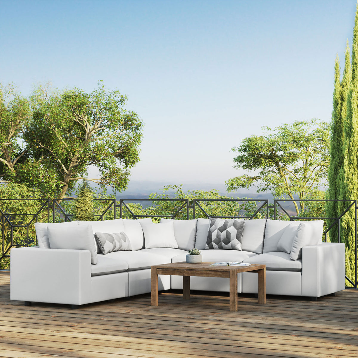 White Commix outdoor sectional defining a bright deck seating area with a wood table and lush garden views. || EEI-5589-WHI || front_angle_room