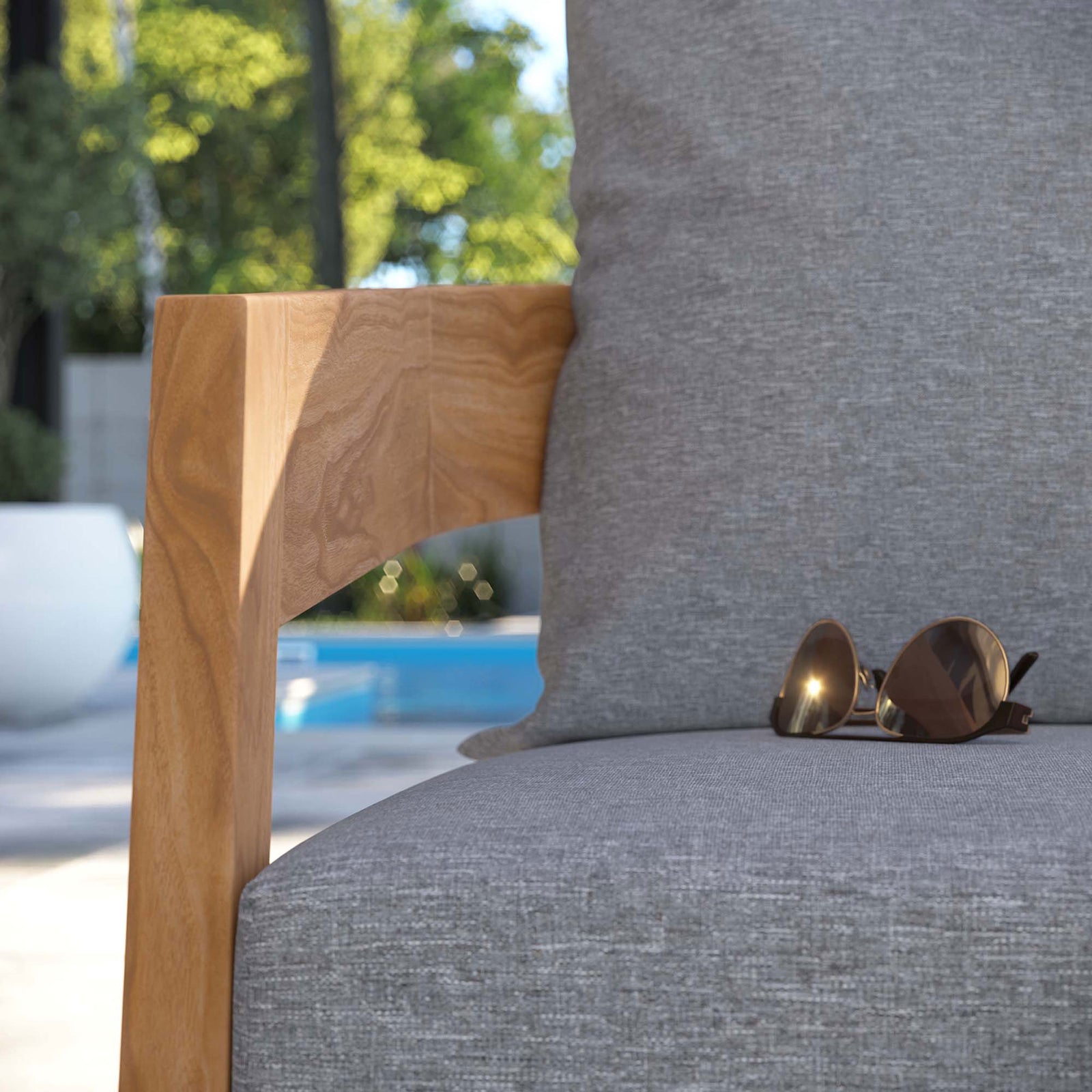 Teak arm and gray cushion of outdoor armchair styled by the pool for relaxed resort inspired lounging || EEI-5602-NAT-GRY || detail_room