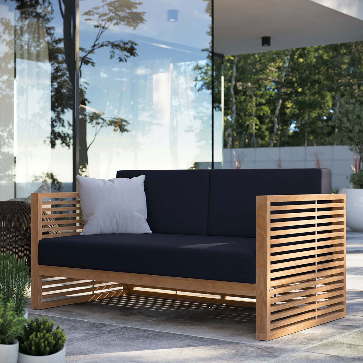 Carlsbad teak outdoor loveseat with navy cushions arranged on a sleek terrace overlooking lush greenery. || EEI-5605-NAT-NAV || front_angle_room