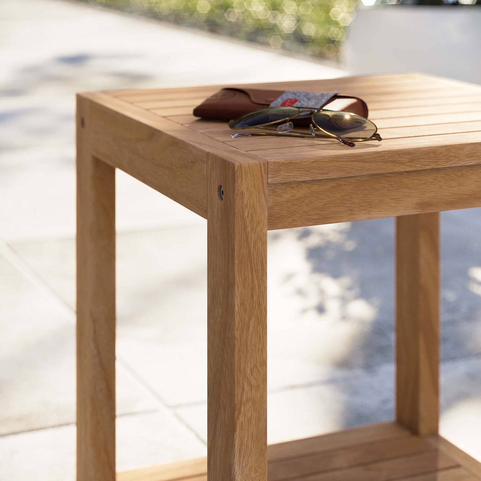 Teak outdoor side table styled with sunglasses on a sunny patio walkway || EEI-5607-NAT || detail_room