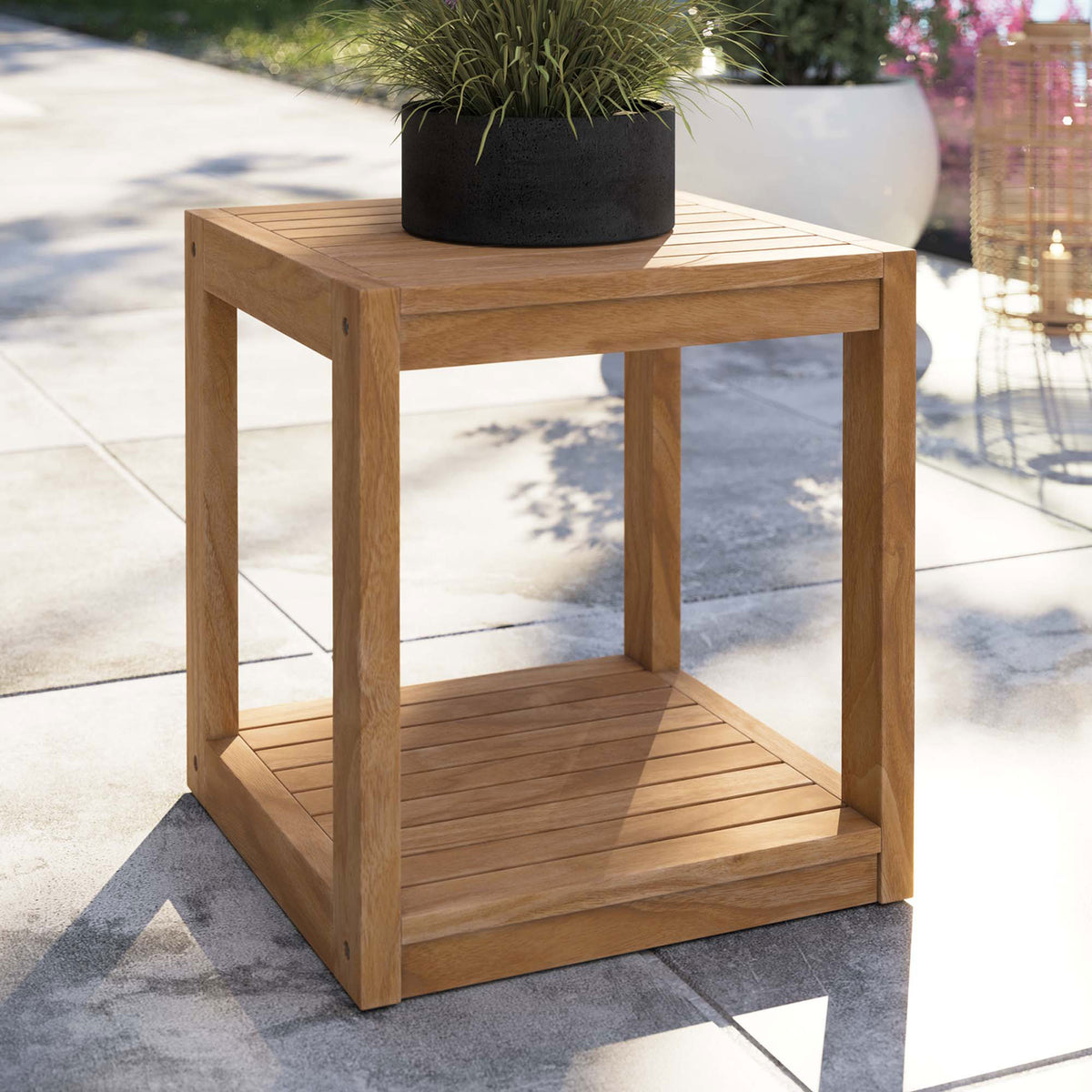 Teak cube side table on a modern patio, styled with a planter on the slatted tabletop || EEI-5607-NAT || front_angle_room