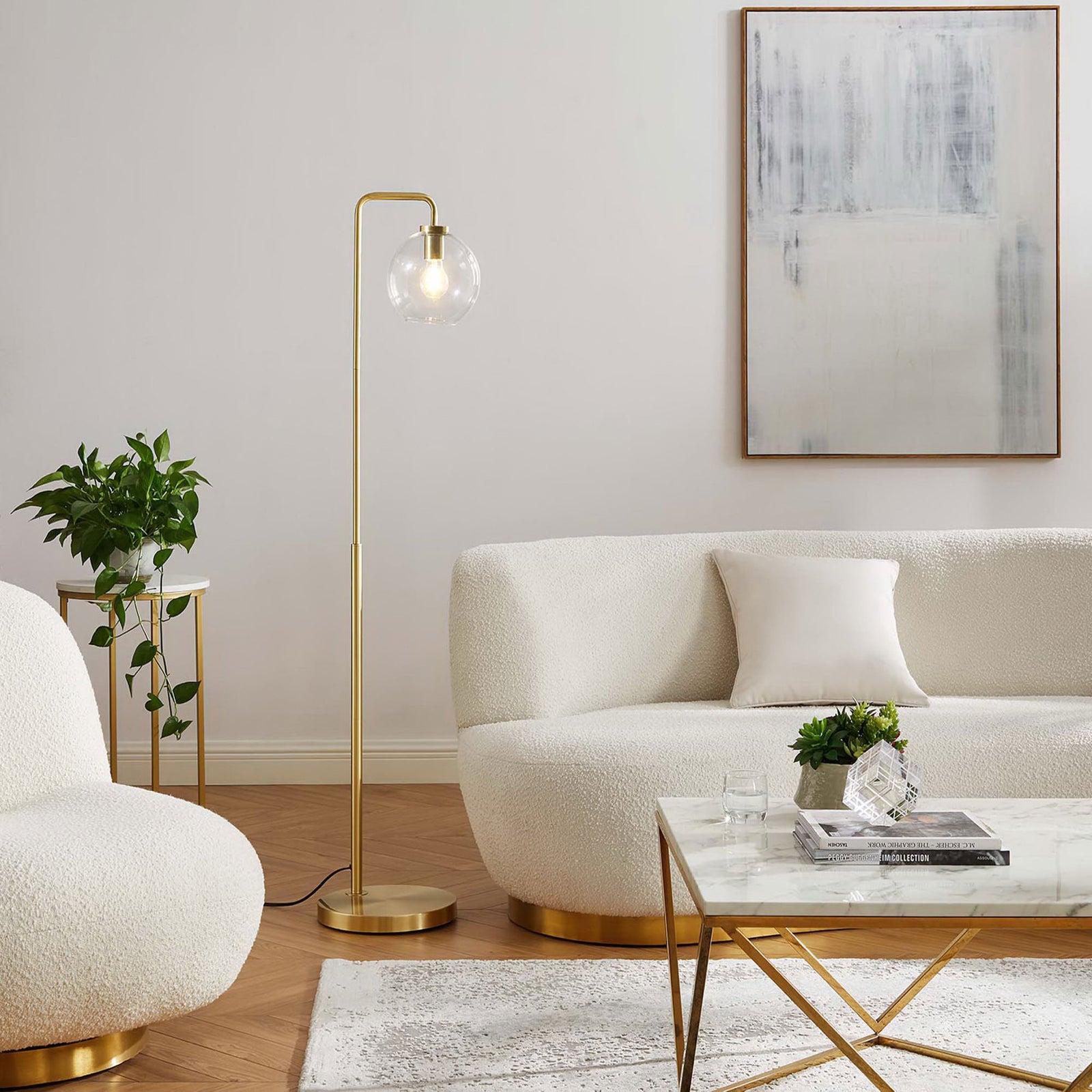 Illuminated satin brass floor lamp with glowing glass globe adding warm light to modern living room || EEI-5616-SBR || front_angle_on_room