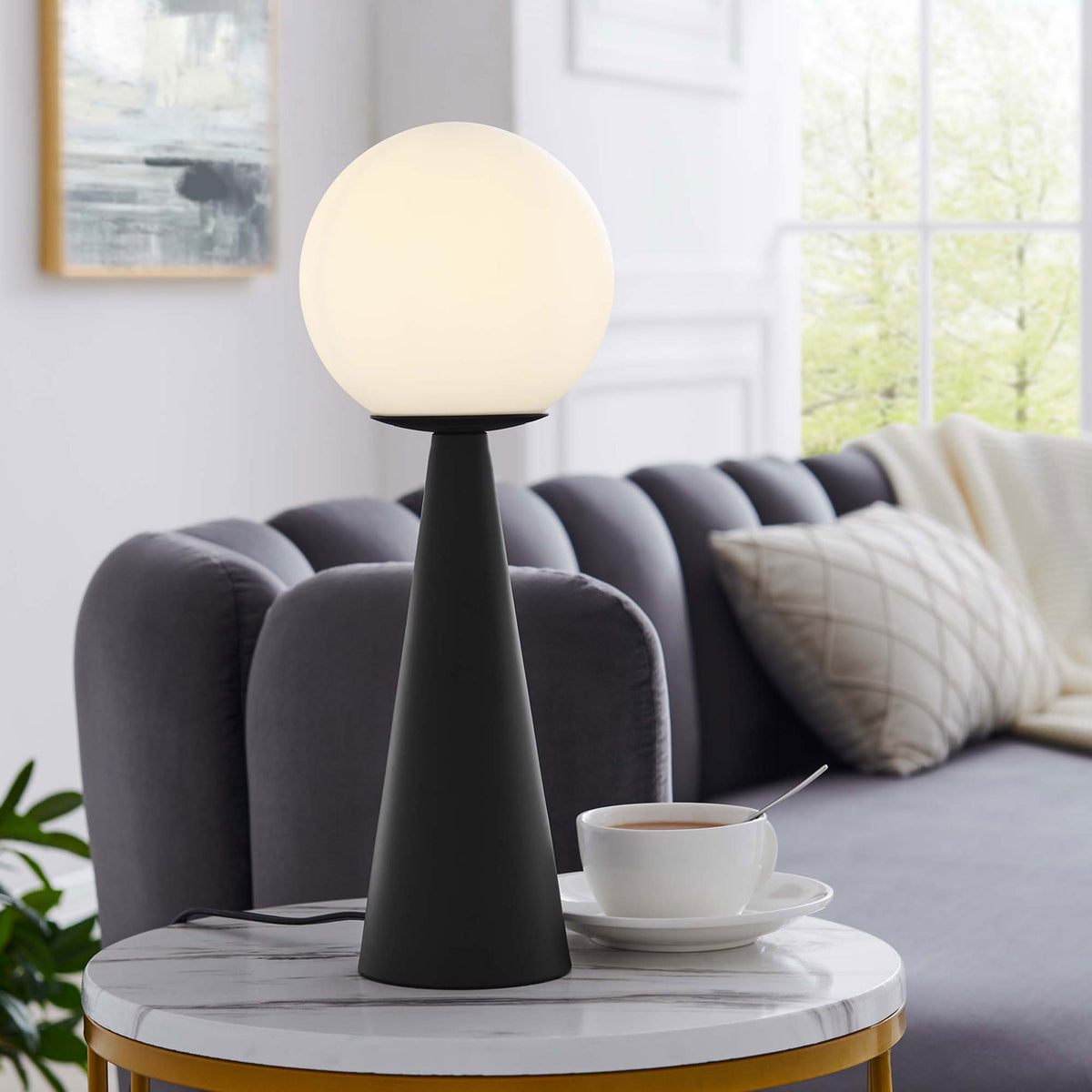 Warmly glowing globe lamp adding ambient light on a marble accent table in a chic lounge || EEI-5621-WHI-BLK || front_angle_on_room