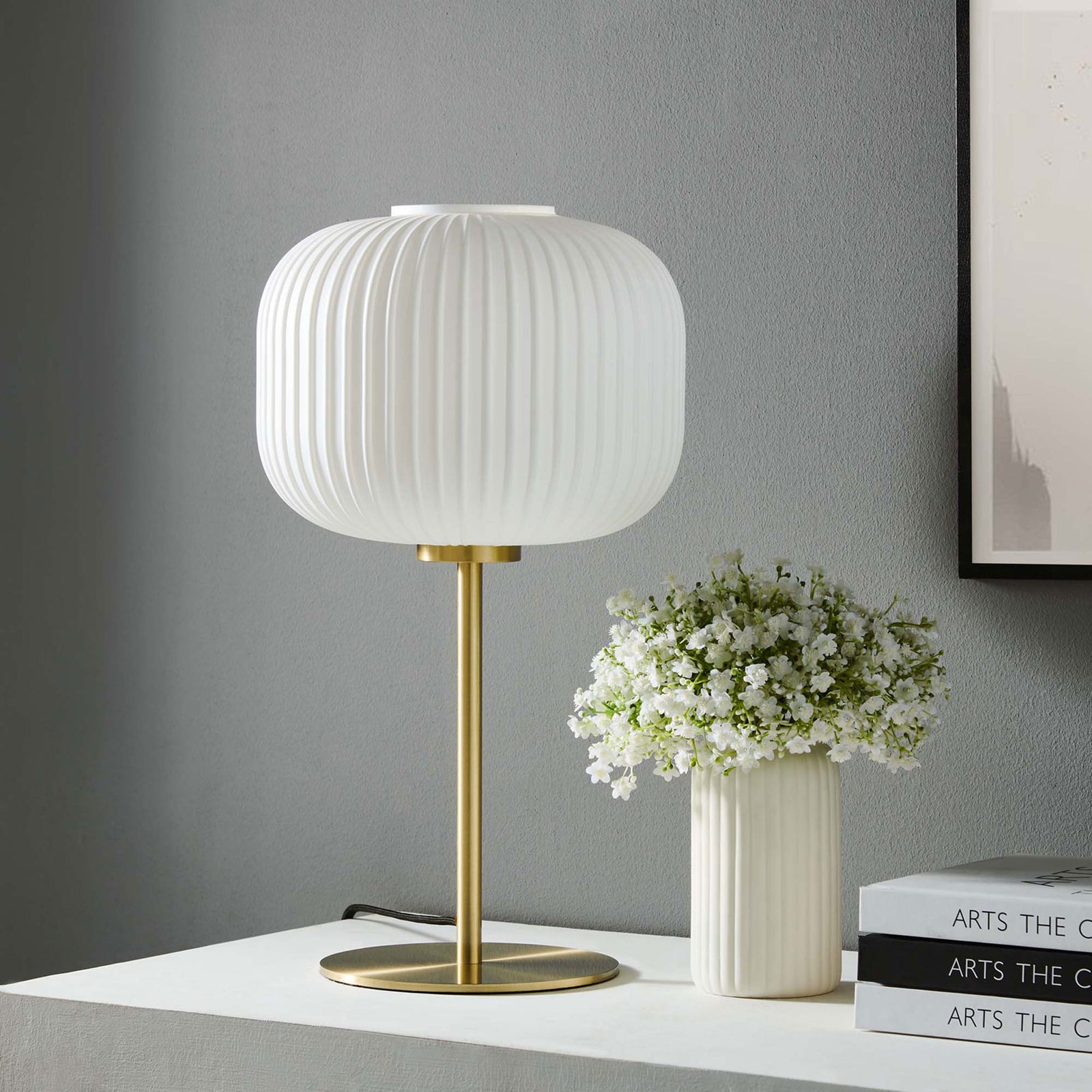 White glass and satin brass table lamp styled on a console with ceramic vase and books || EEI-5622-WHI-SBR || front_room