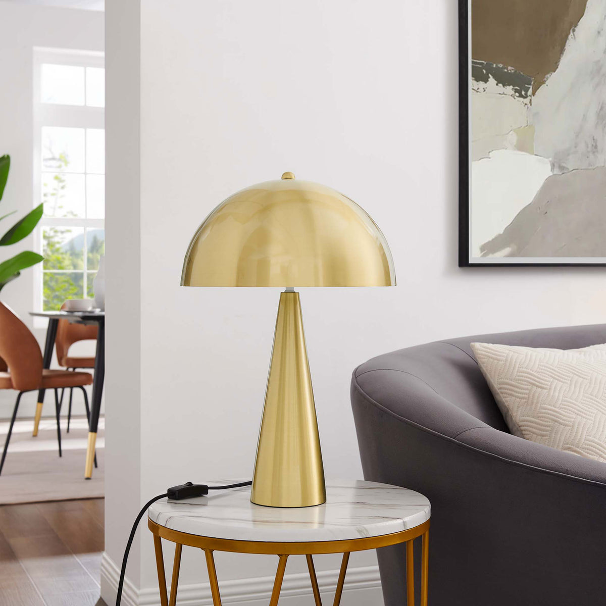Satin brass Selena lamp styled on a marble-topped side table beside a contemporary sofa || EEI-5624-SBR || front_room